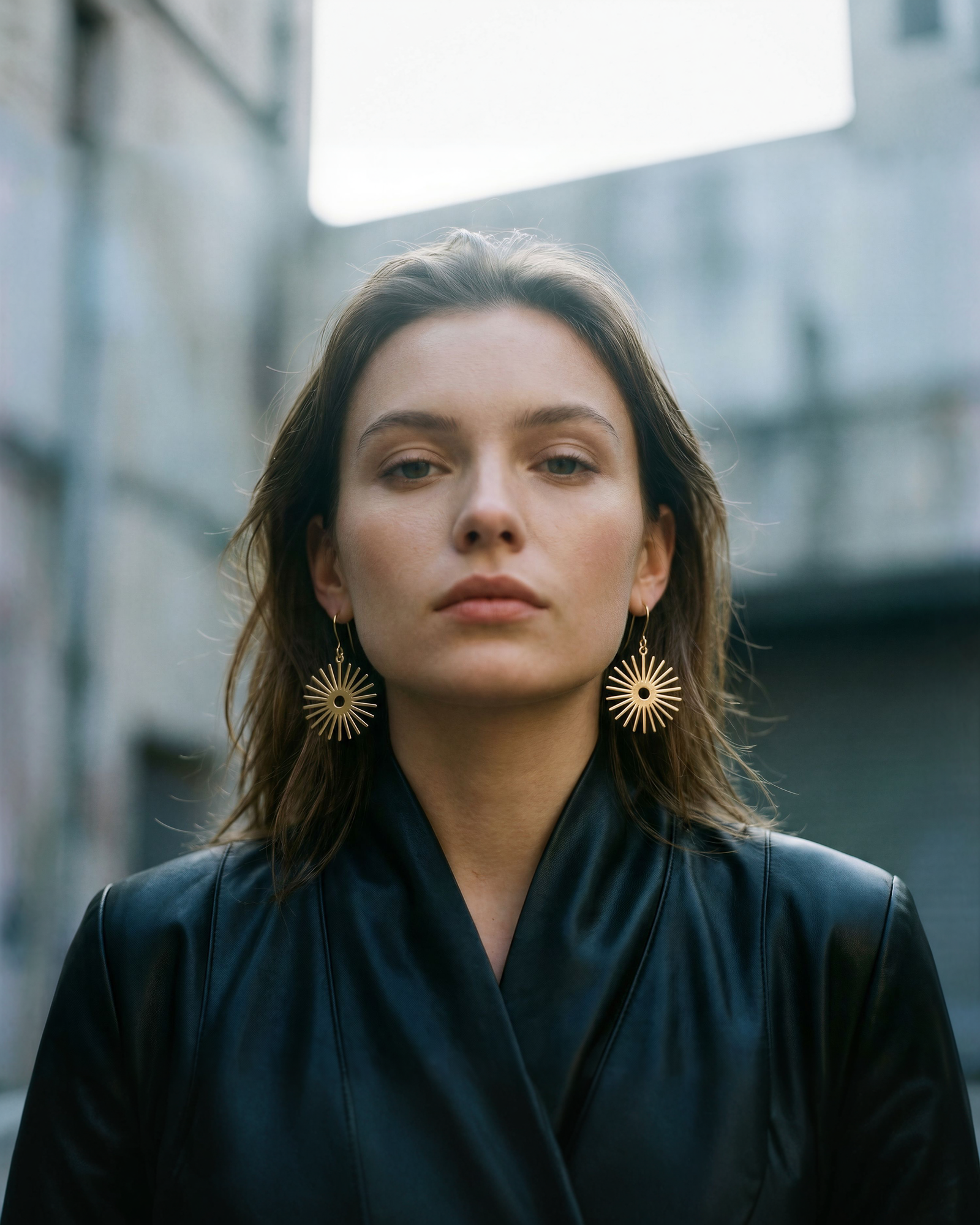 Woman wearing the Eos Sun Sunrise Earrings in all gold colour way from Lawless Jewellery