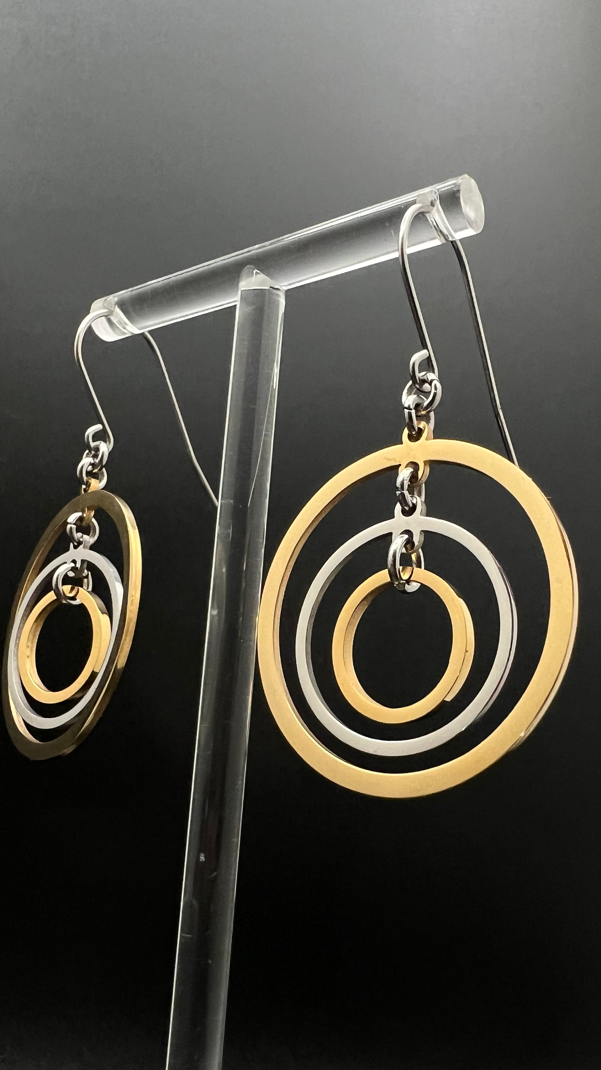 Mixed-metal stainless steel earrings with three interlinked concentric gold and silver rings and stainless steel ear hooks, 5 cm length — Lawless Jewellery.