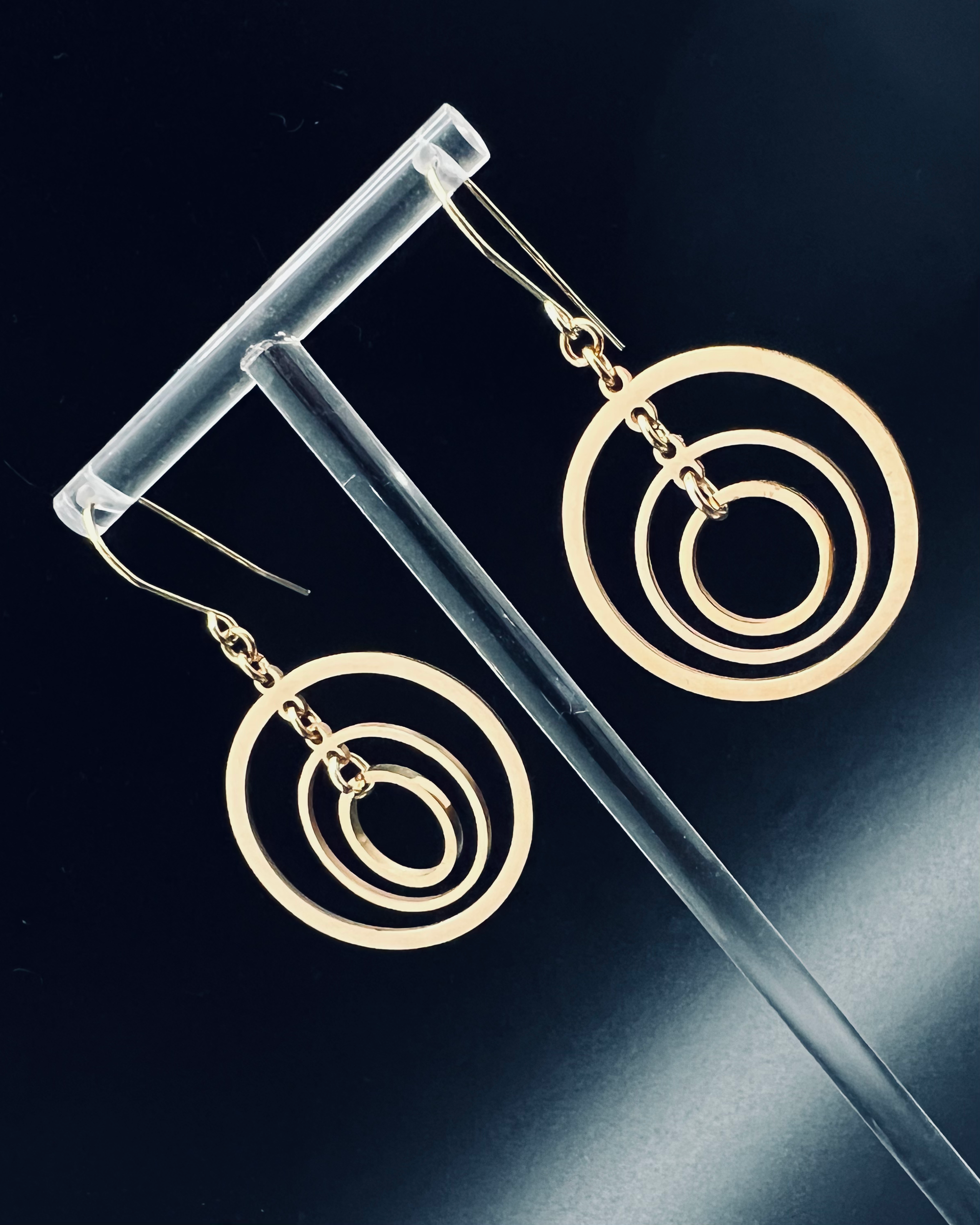 Gold triple-ring halo earrings with three interlinked high-polish rings and gold-plated stainless steel ear hooks, 5 cm length — Lawless Jewellery.