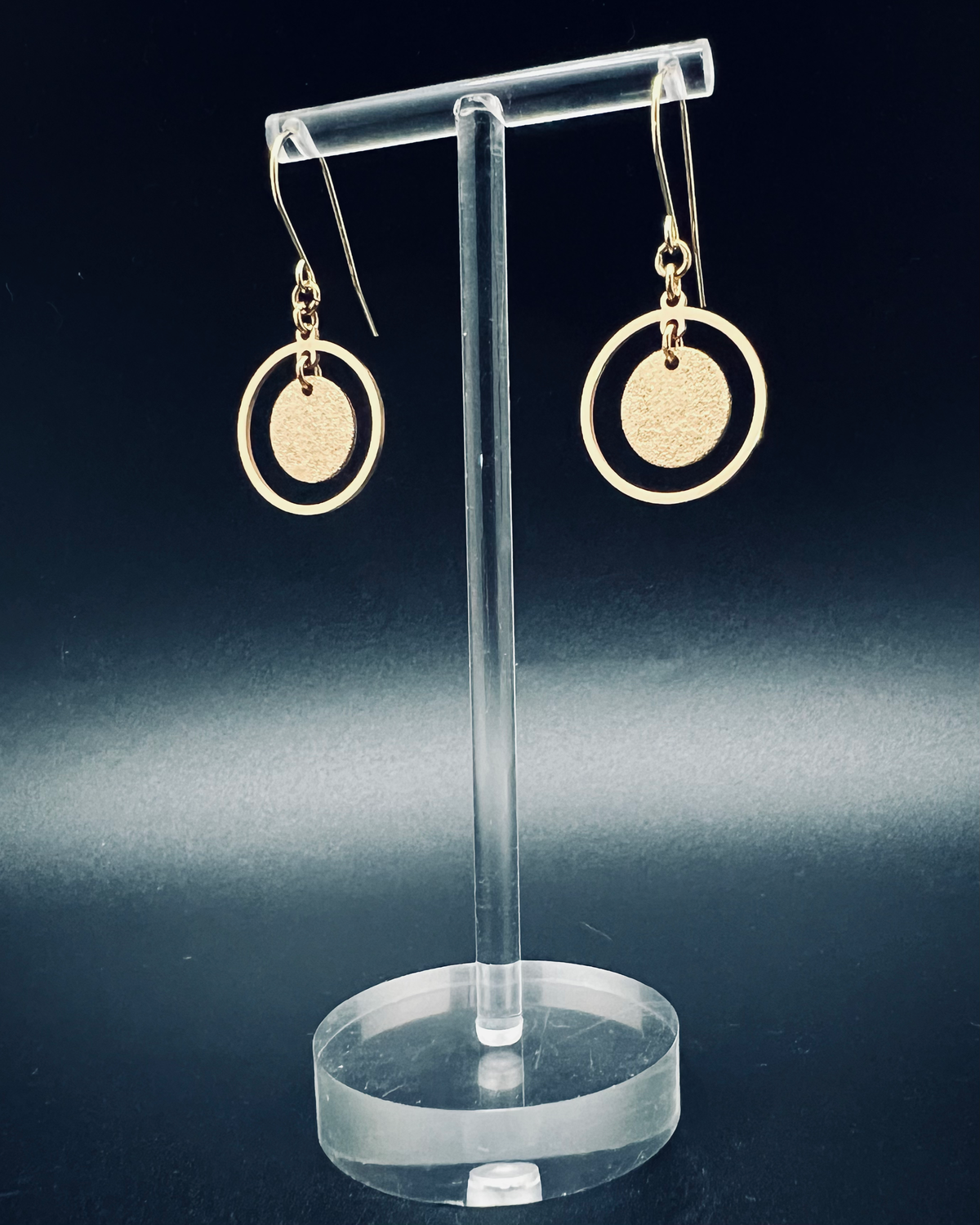 Gold stainless steel halo earrings featuring a circular frame with a textured gold disc suspended inside, lightweight 4 cm design — Lawless Jewellery.