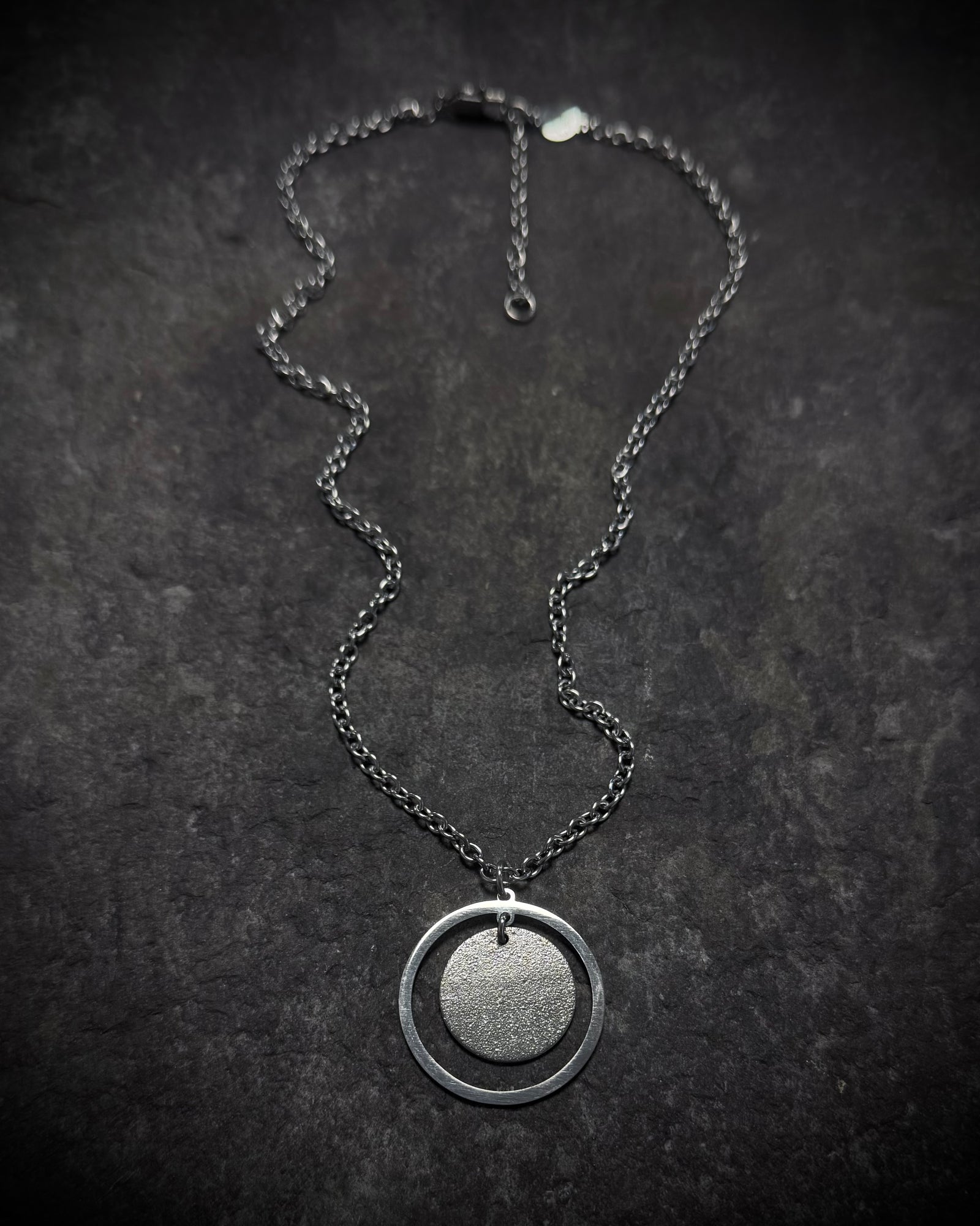 Cassini Halo necklace in high-polish silver stainless steel featuring a 30mm circular ring pendant with a minimalist celestial design
