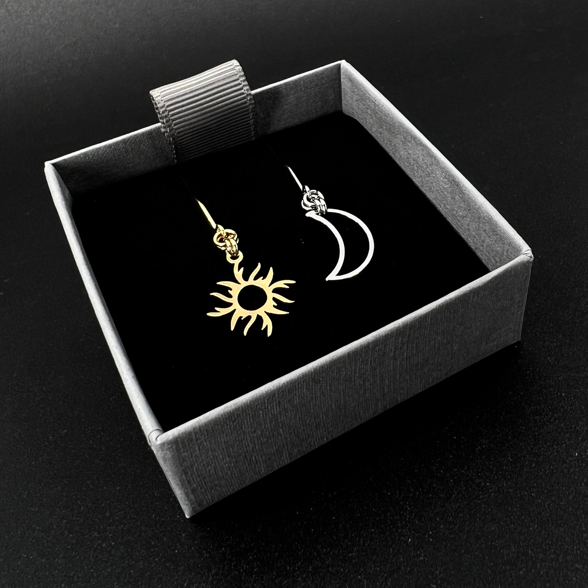 Mixed metal sun and moon earrings with silver crescent moon and gold sun charms on stainless steel hooks, Eos Dawn Earrings by Lawless Jewellery.