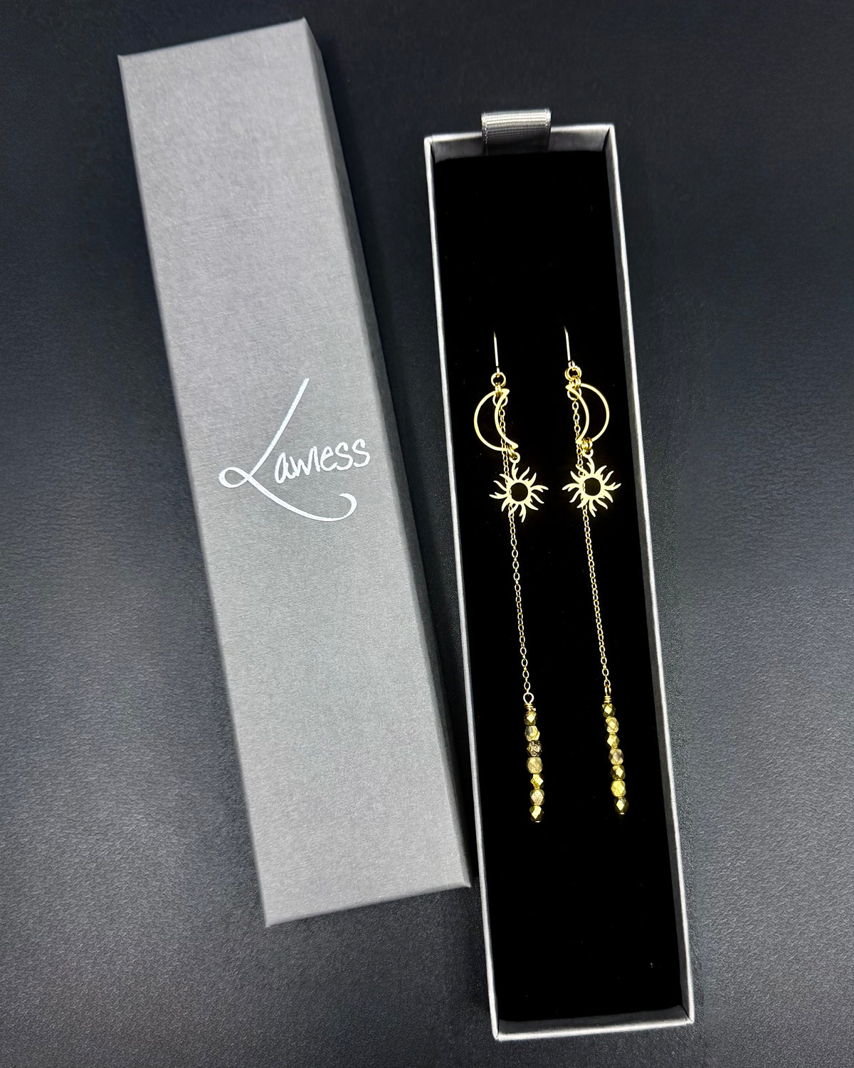 Long gold celestial earrings featuring crescent moon and sun charms with extended chain and fire-polished crystal, Eos Threshold Earrings by Lawless Jewellery.