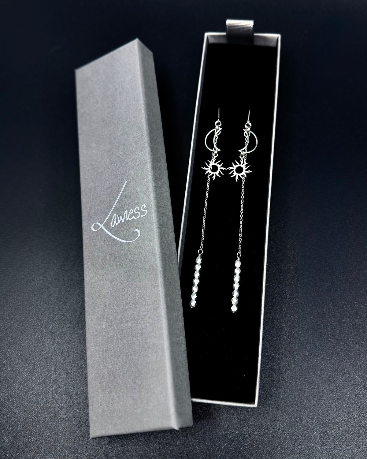 Long silver celestial earrings with crescent moon and sun charms, extended chain and fire-polished crystal, Eos Threshold Earrings by Lawless Jewellery.