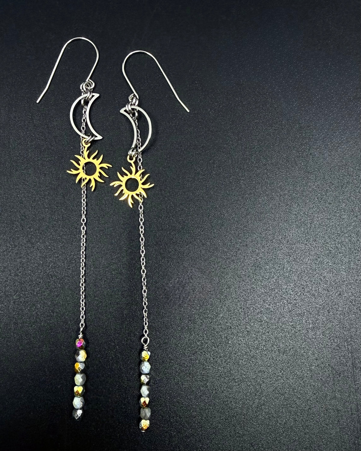 Long mixed-metal celestial earrings with silver crescent moon, gold sun charm, extended chain and fire-polished crystal, Eos Threshold Earrings by Lawless Jewellery.