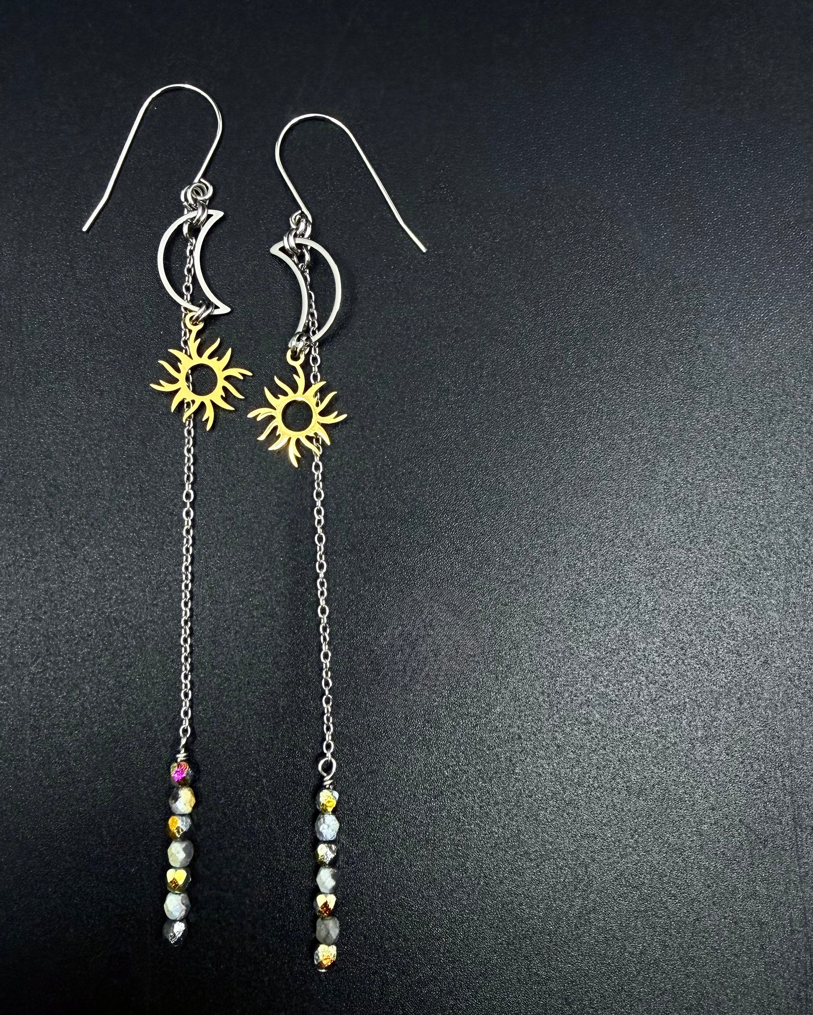 Long mixed-metal celestial earrings with silver crescent moon, gold sun charm, extended chain and fire-polished crystal, Eos Threshold Earrings by Lawless Jewellery.