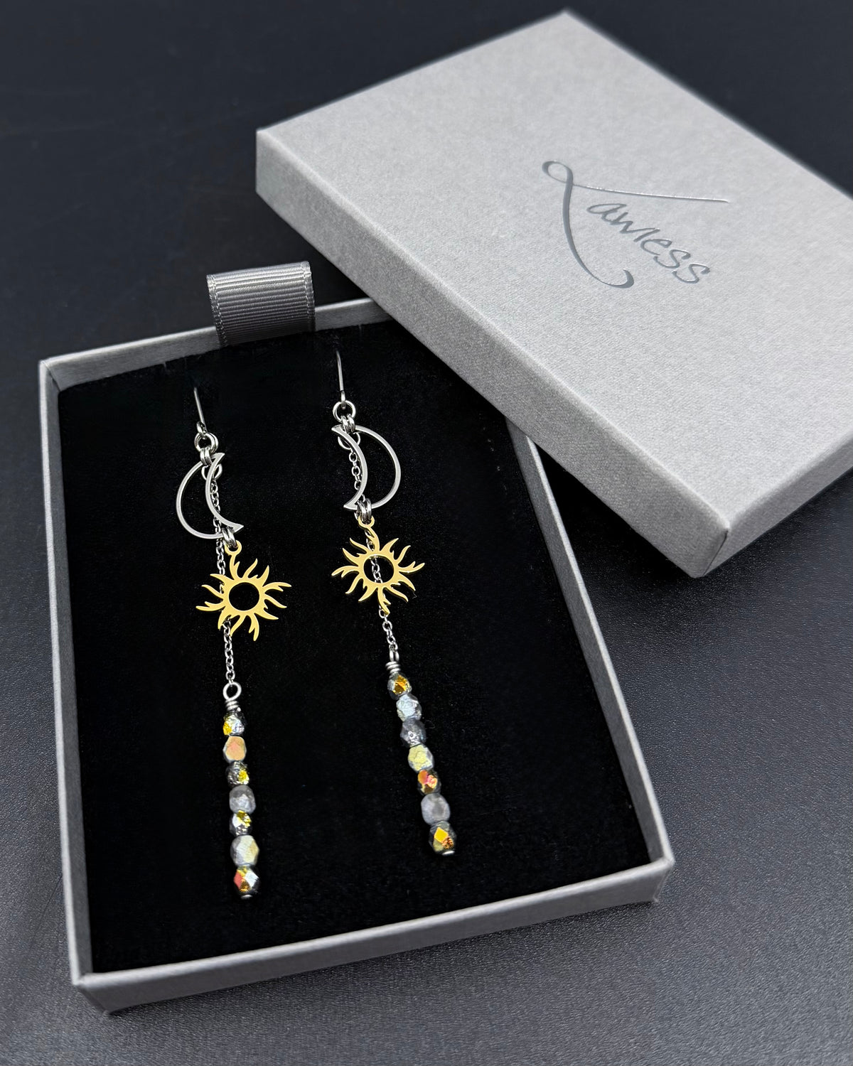 Long mixed-metal celestial earrings with silver moon and gold sun charms and fire-polished crystal drops from the Lawless Eos Threshold collection.