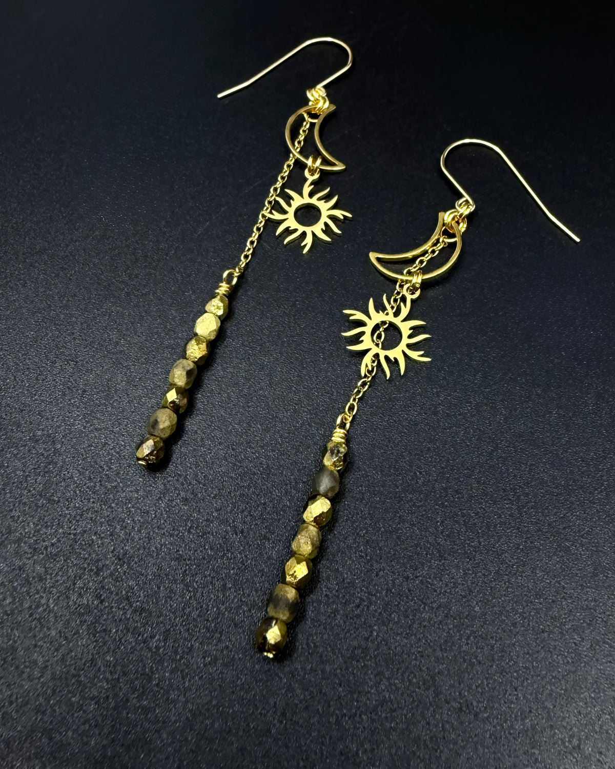 Long gold celestial earrings featuring sun and moon charms with fire-polished crystal drops from the Lawless Eos Threshold collection