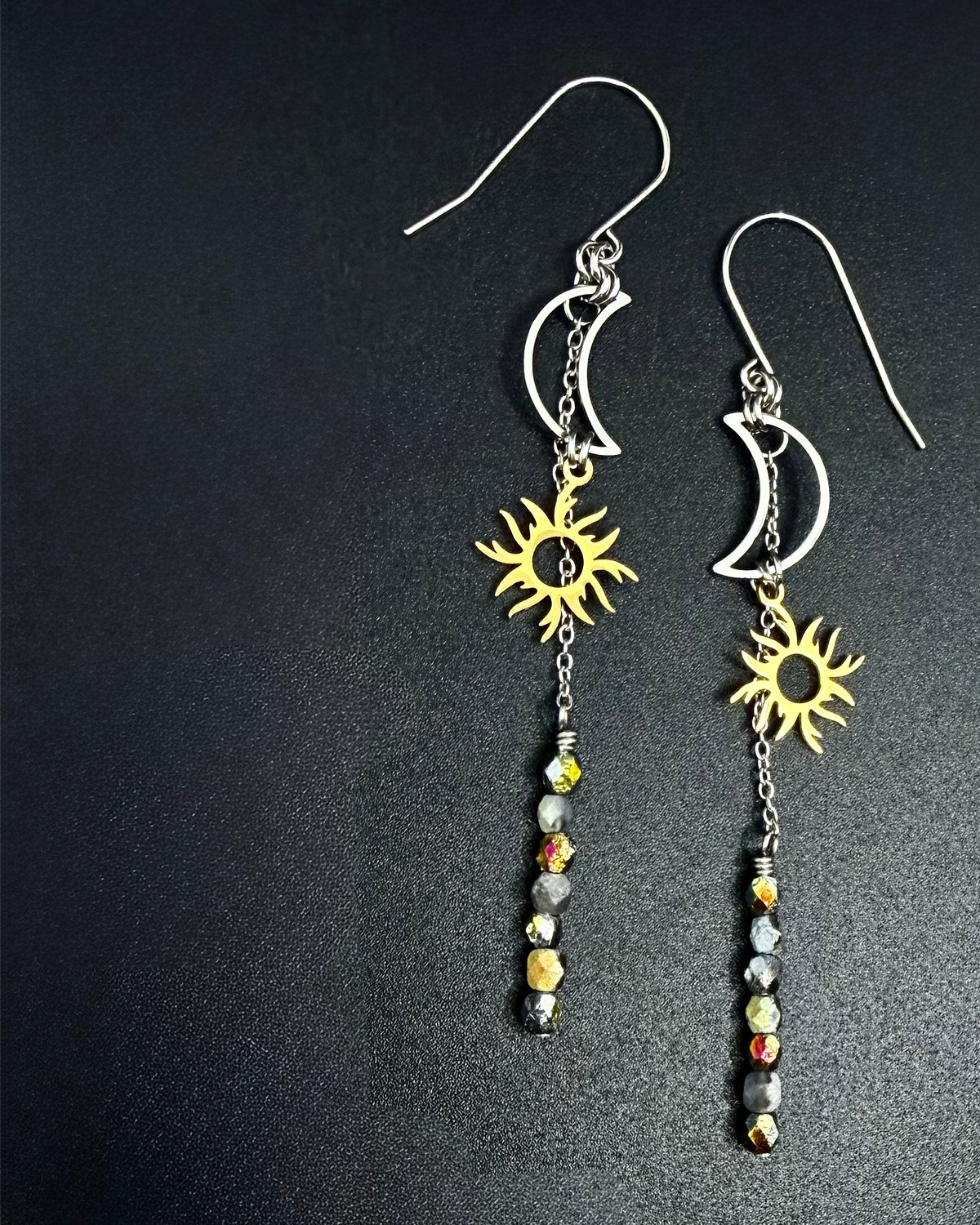 Long mixed-metal celestial earrings with silver moon and gold sun charms and fire-polished crystal drops from the Lawless Eos Threshold collection.