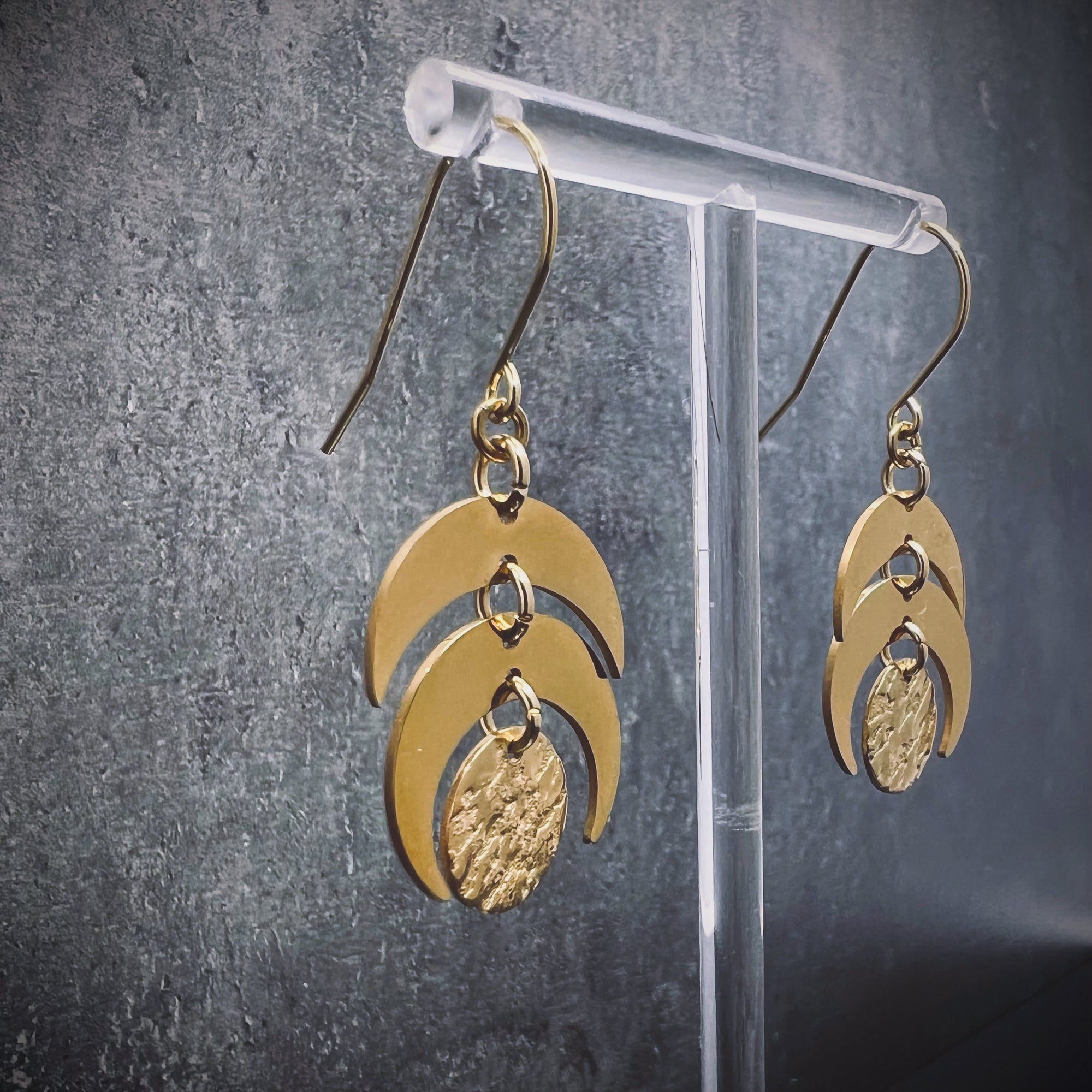 Gold stainless steel lunar-inspired earrings featuring layered crescents and a textured gold disc, 20 mm wide with a 4 cm drop — Lawless Jewellery.