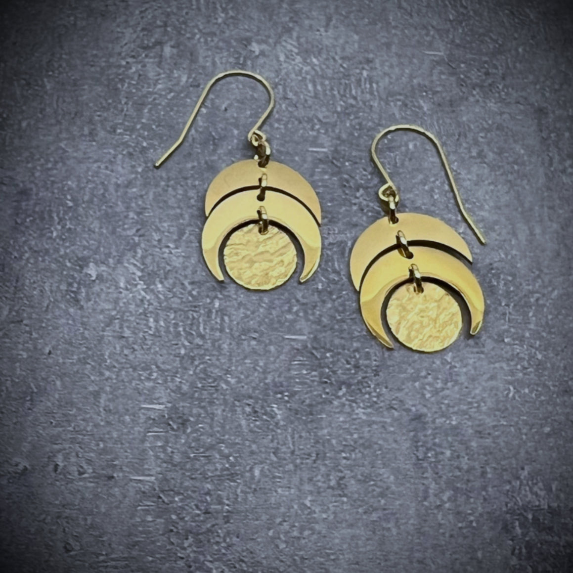 Gold stainless steel lunar-inspired earrings featuring layered crescents and a textured gold disc, 20 mm wide with a 4 cm drop — Lawless Jewellery.