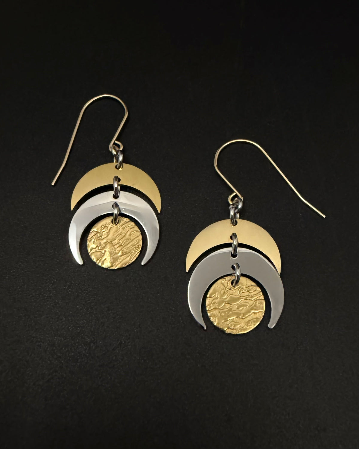 Mixed metal Luna Phase Earrings in gold and silver with sculptural crescent design and textured gold disc, 20mm width, stainless steel.