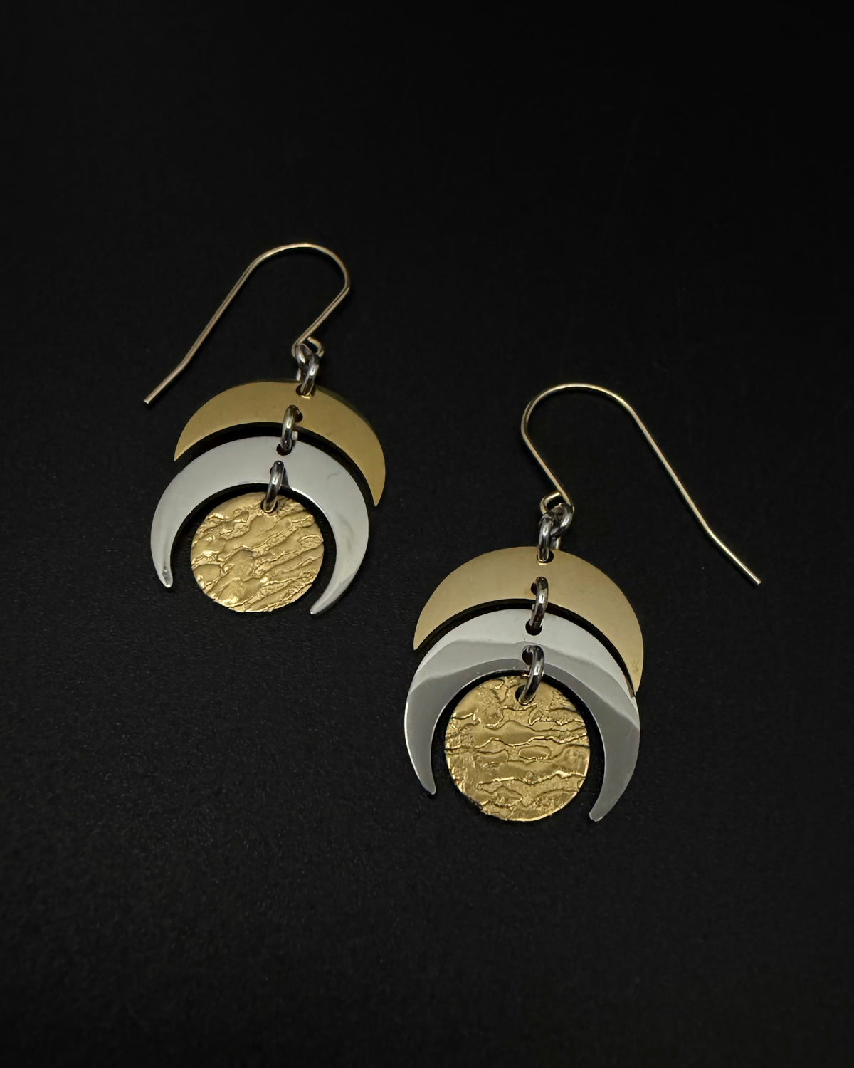 Mixed metal Luna Phase Earrings in gold and silver with sculptural crescent design and textured gold disc, 20mm width, stainless steel.