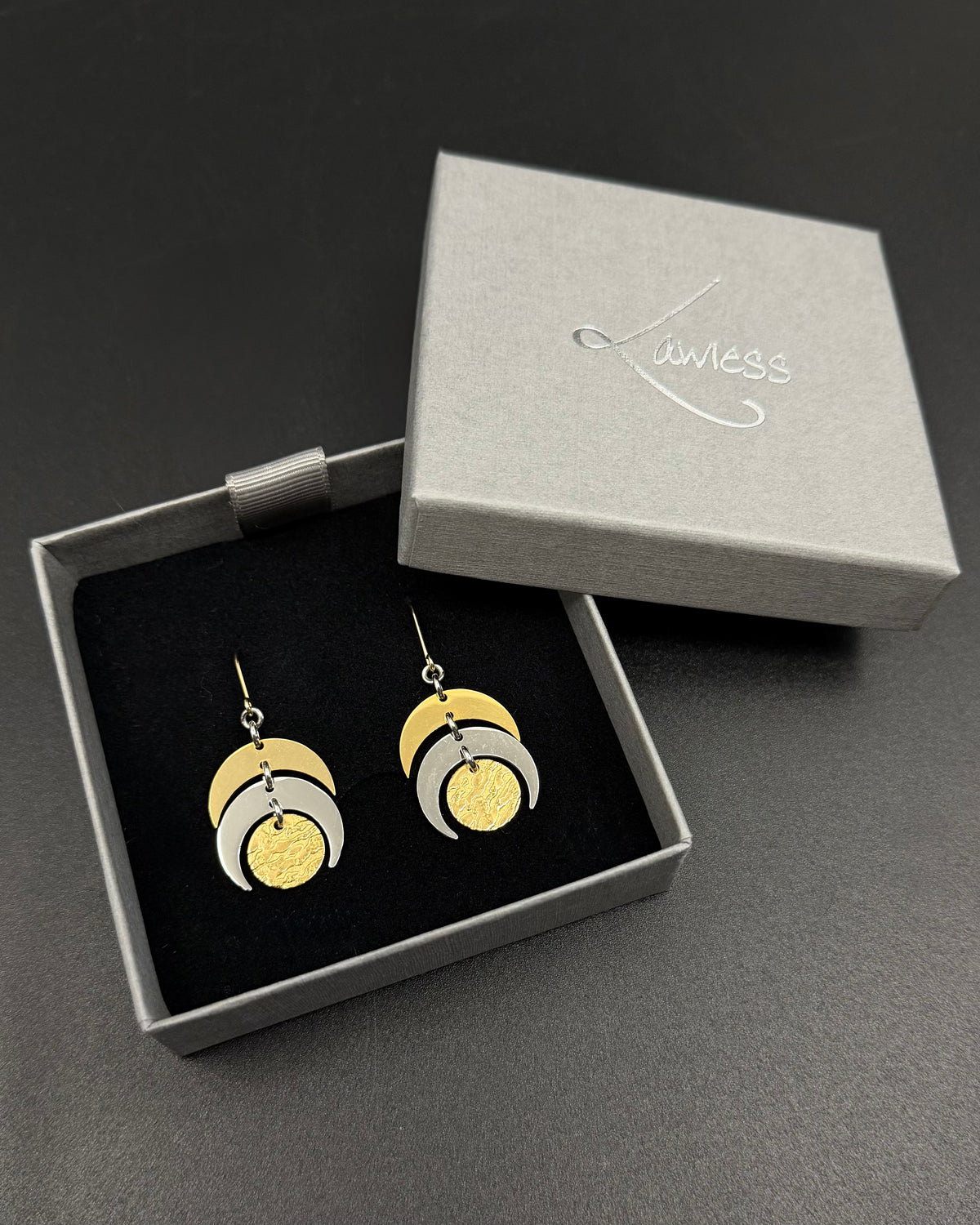 Mixed metal Luna Phase Earrings in gold and silver with sculptural crescent design and textured gold disc, 20mm width, stainless steel.