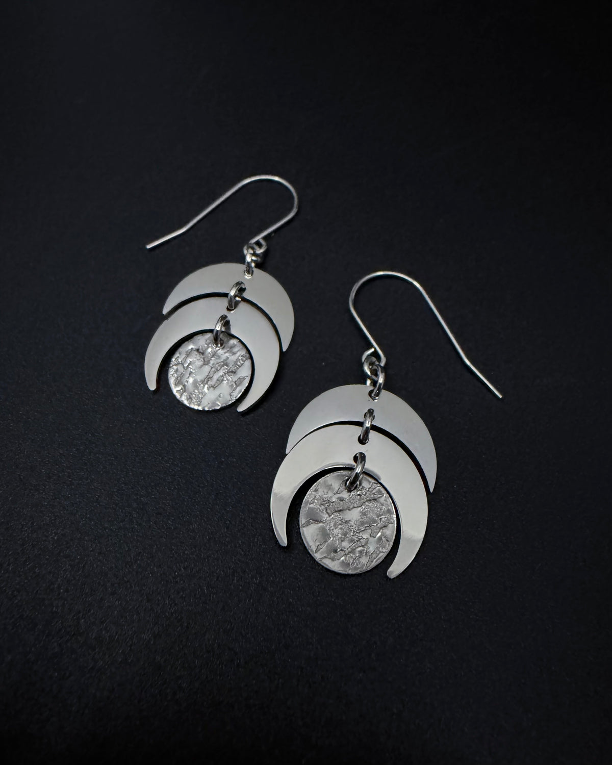 Silver Luna Phase Earrings with polished stainless-steel crescents and textured central disc, 20 mm wide and 4 cm long — Lawless Jewellery