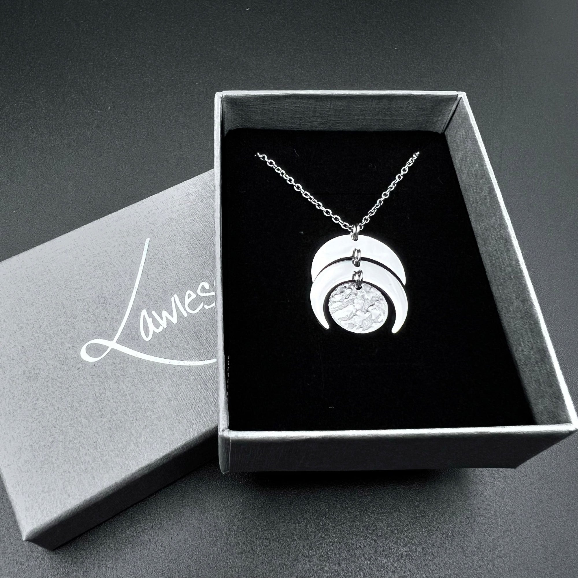 Silver stainless steel Luna Phase necklace with sculptural crescent and disc pendant on an adjustable chain, 20 mm wide — Lawless Jewellery.