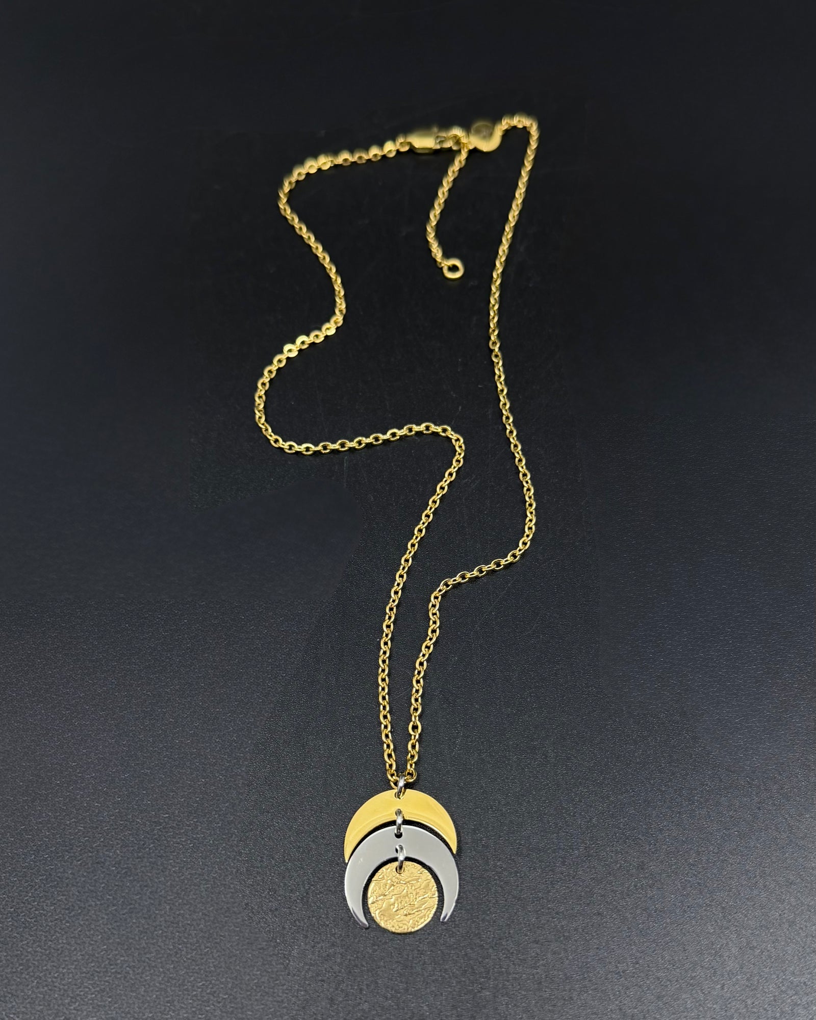 Mixed metal Luna Phase Necklace with silver and gold crescent moon design and textured gold disc on adjustable gold-tone chain