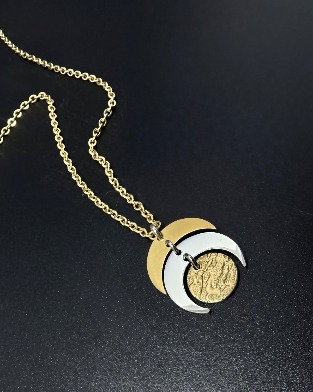 Mixed metal Luna Phase Necklace with silver and gold crescent moon design and textured gold disc on adjustable gold-tone chain