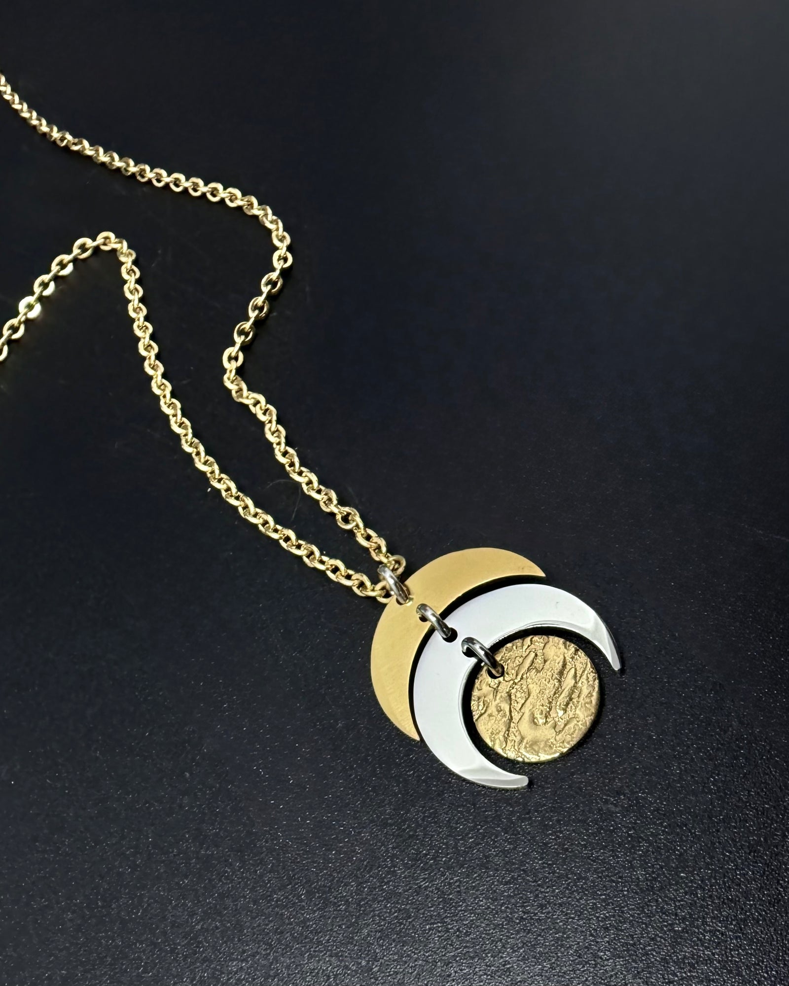 Mixed metal Luna Phase Necklace with silver and gold crescent moon design and textured gold disc on adjustable gold-tone chain