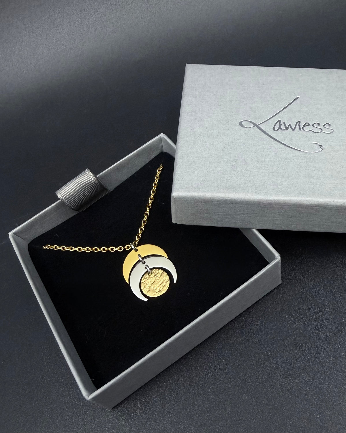 Mixed metal Luna Phase Necklace with silver and gold crescent moon design and textured gold disc on adjustable gold-tone chain