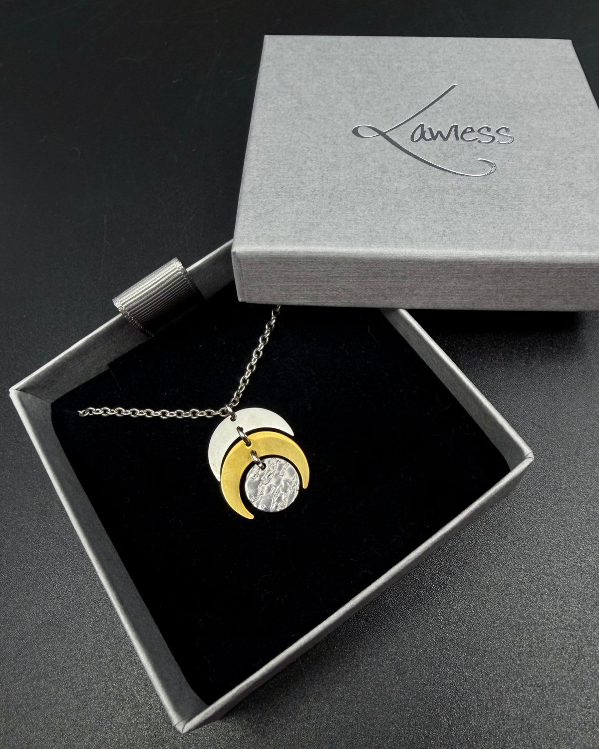 Mixed metal Luna Phase Necklace with silver and gold crescent moon design and textured gold disc on adjustable gold-tone chain