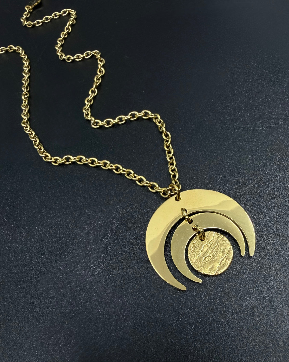 All gold Luna Phase necklace with 30mm sculptural crescent moon pendant and textured disc on stainless steel toggle chain, celestial statement jewellery
