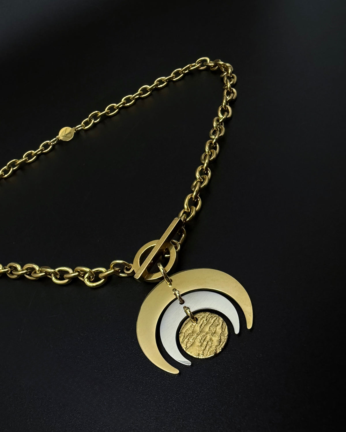 Gold and silver Luna Phase necklace with layered crescent moon pendant on chunky curb chain and toggle clasp, mixed-metal celestial jewellery by Lawless
