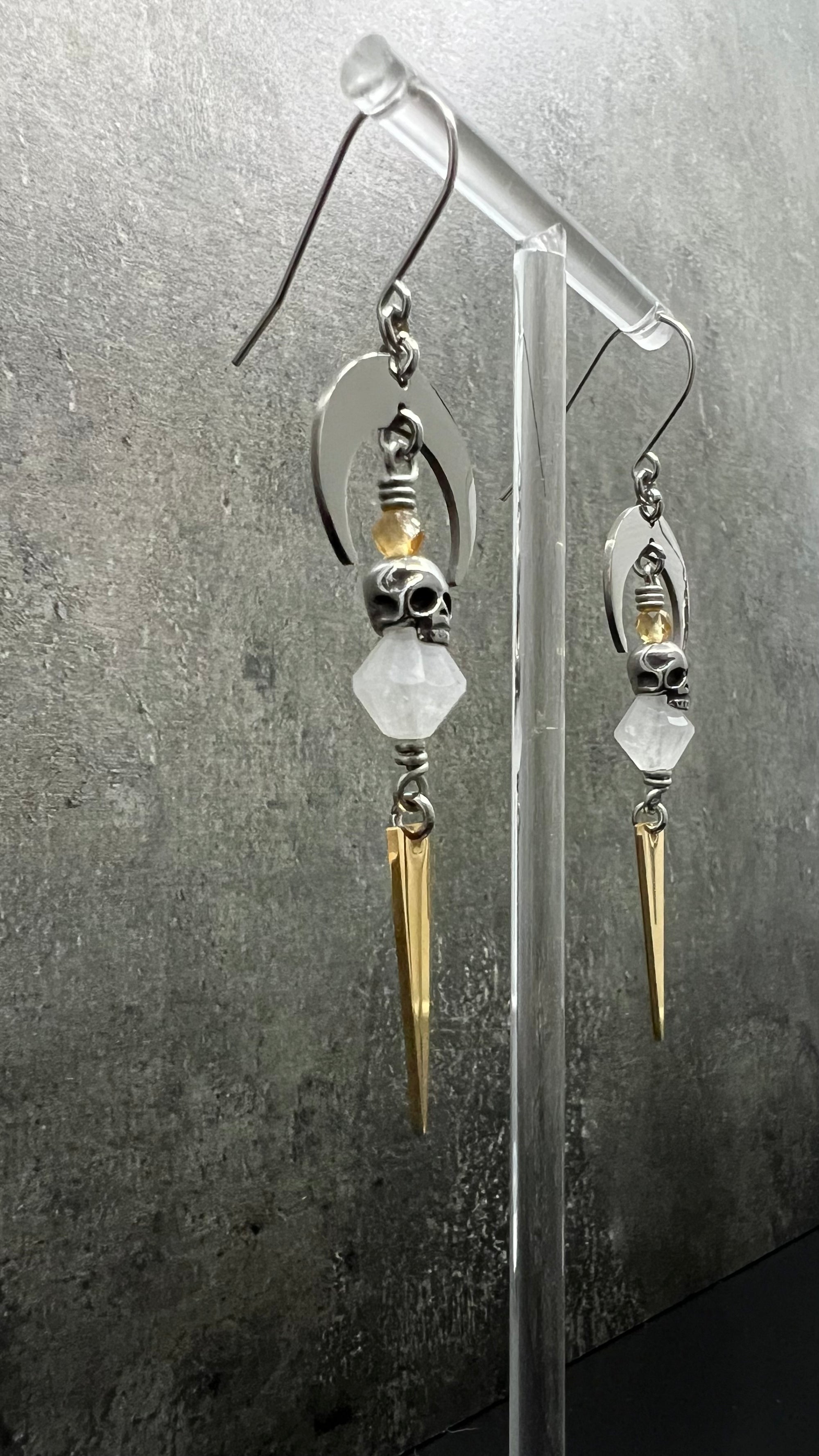 Silver and gold stainless steel arc earrings featuring Citrine and Quartz Crystal with 3D skull details, 8 cm length — Lawless Jewellery.