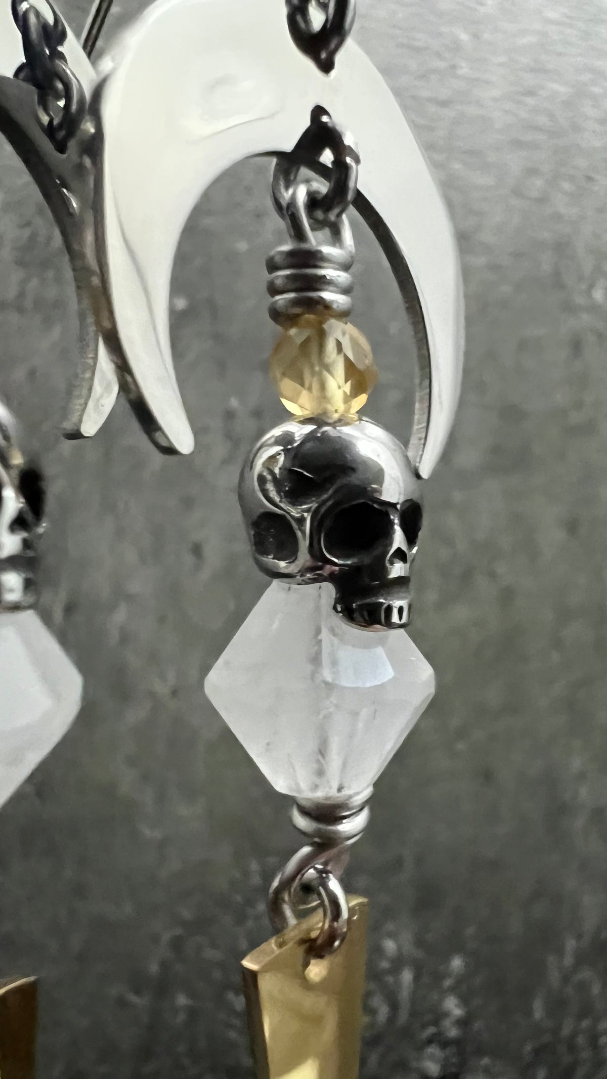 Silver and gold stainless steel arc earrings featuring Citrine and Quartz Crystal with 3D skull details, 8 cm length — Lawless Jewellery.