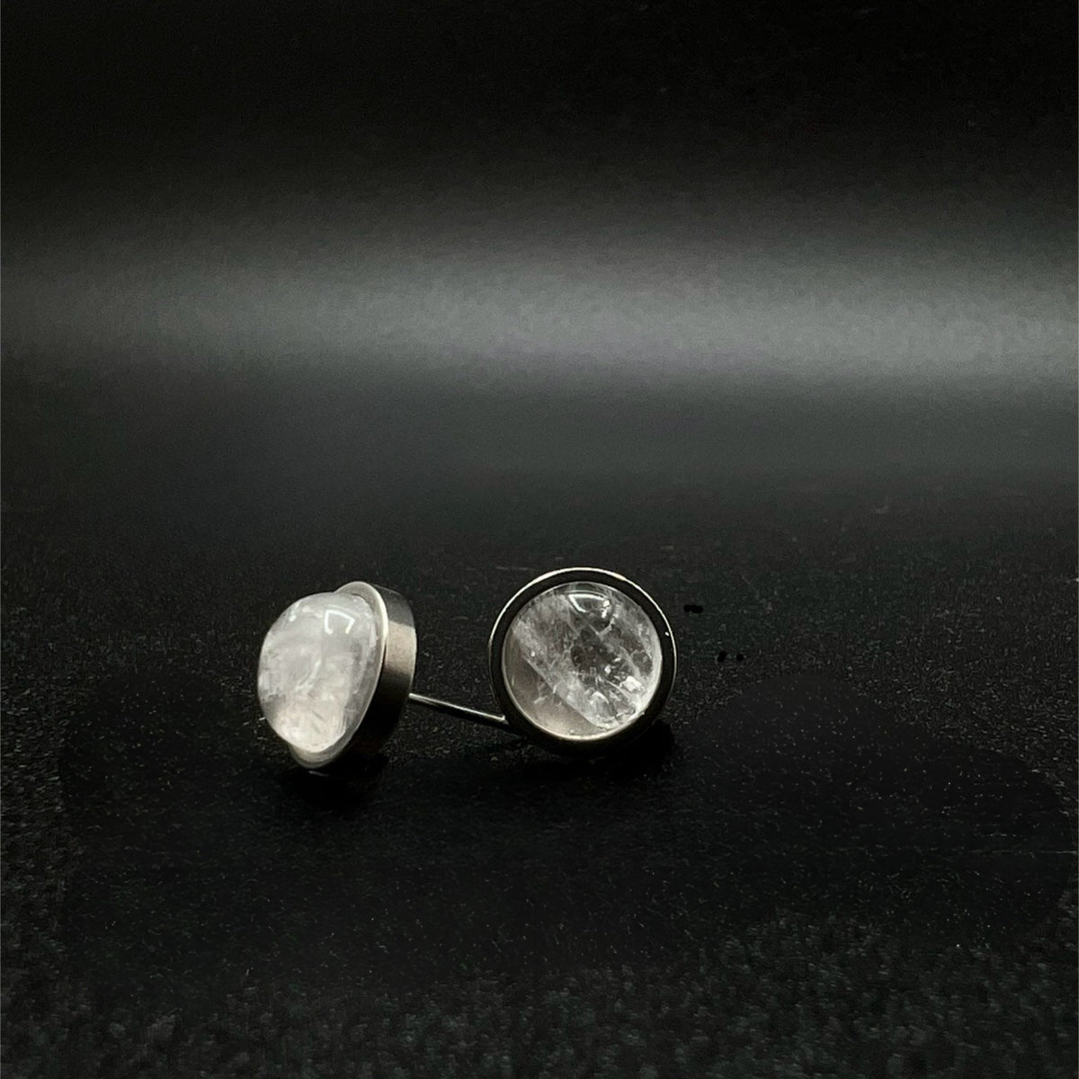 Stainless steel stud earrings featuring 8 mm high-dome natural quartz cabochons in 10 mm settings, clear and highly refractive — Lawless Jewellery.