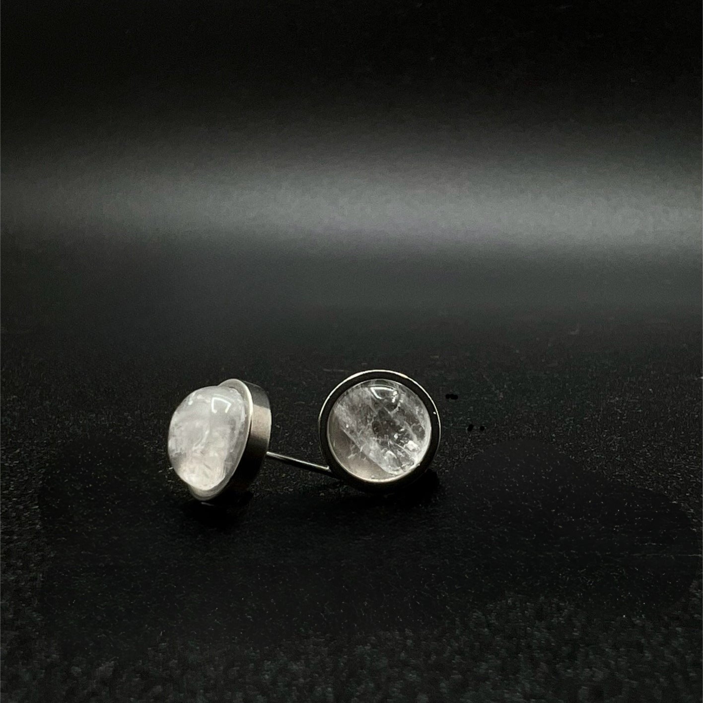 Stainless steel stud earrings featuring 8 mm high-dome natural quartz cabochons in 10 mm settings, clear and highly refractive — Lawless Jewellery.