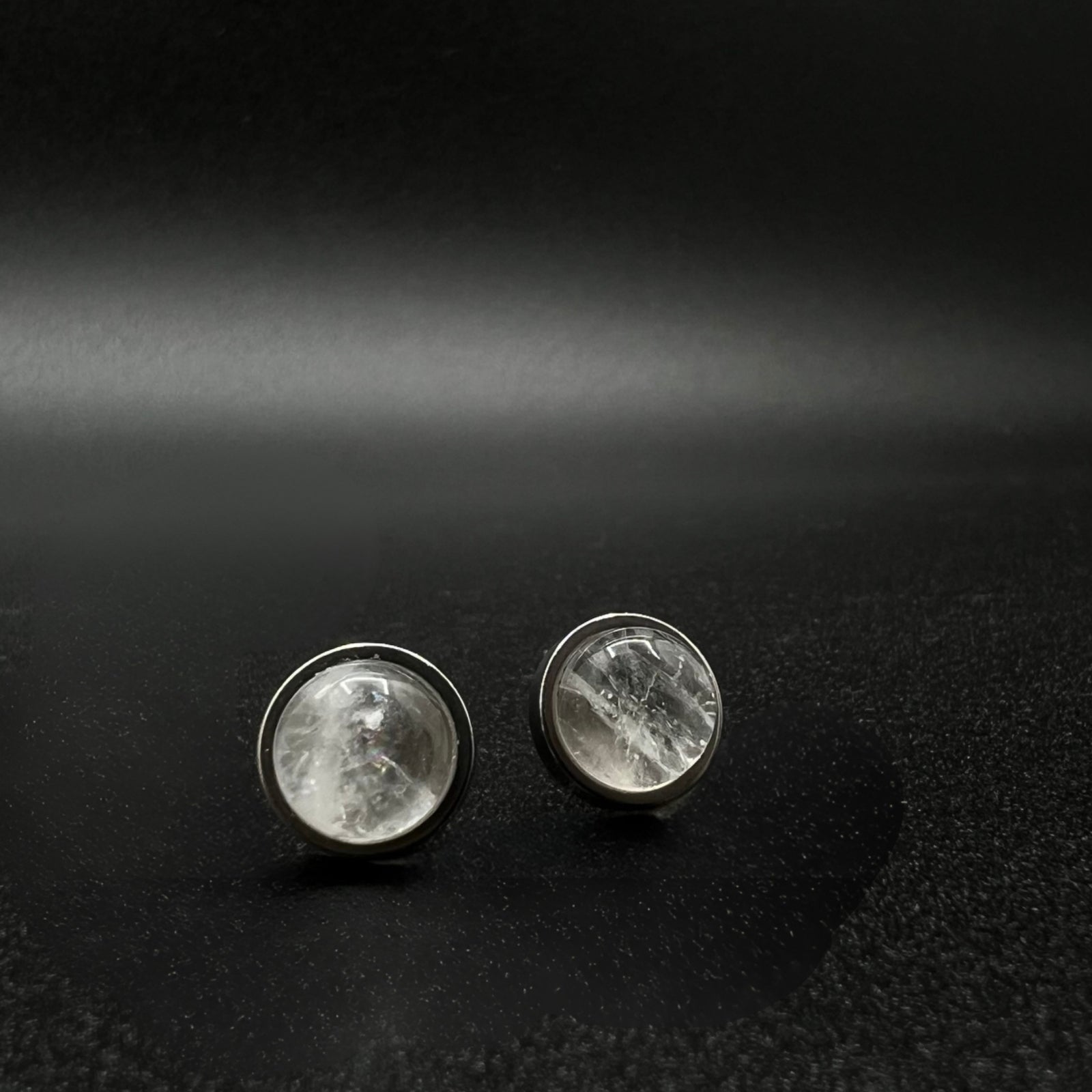 Stainless steel stud earrings featuring 8 mm high-dome natural quartz cabochons in 10 mm settings, clear and highly refractive — Lawless Jewellery.