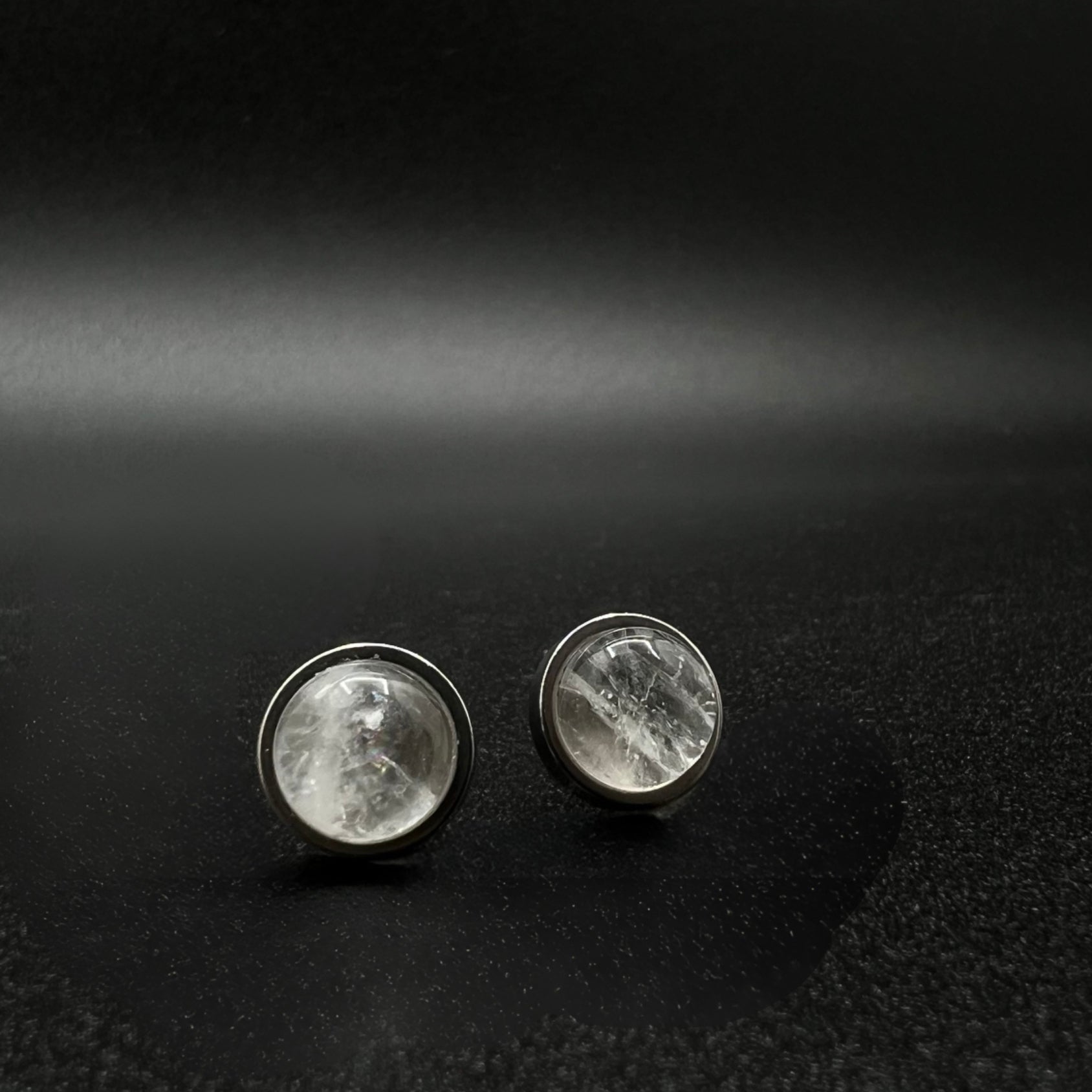 Stainless steel stud earrings featuring 8 mm high-dome natural quartz cabochons in 10 mm settings, clear and highly refractive — Lawless Jewellery.