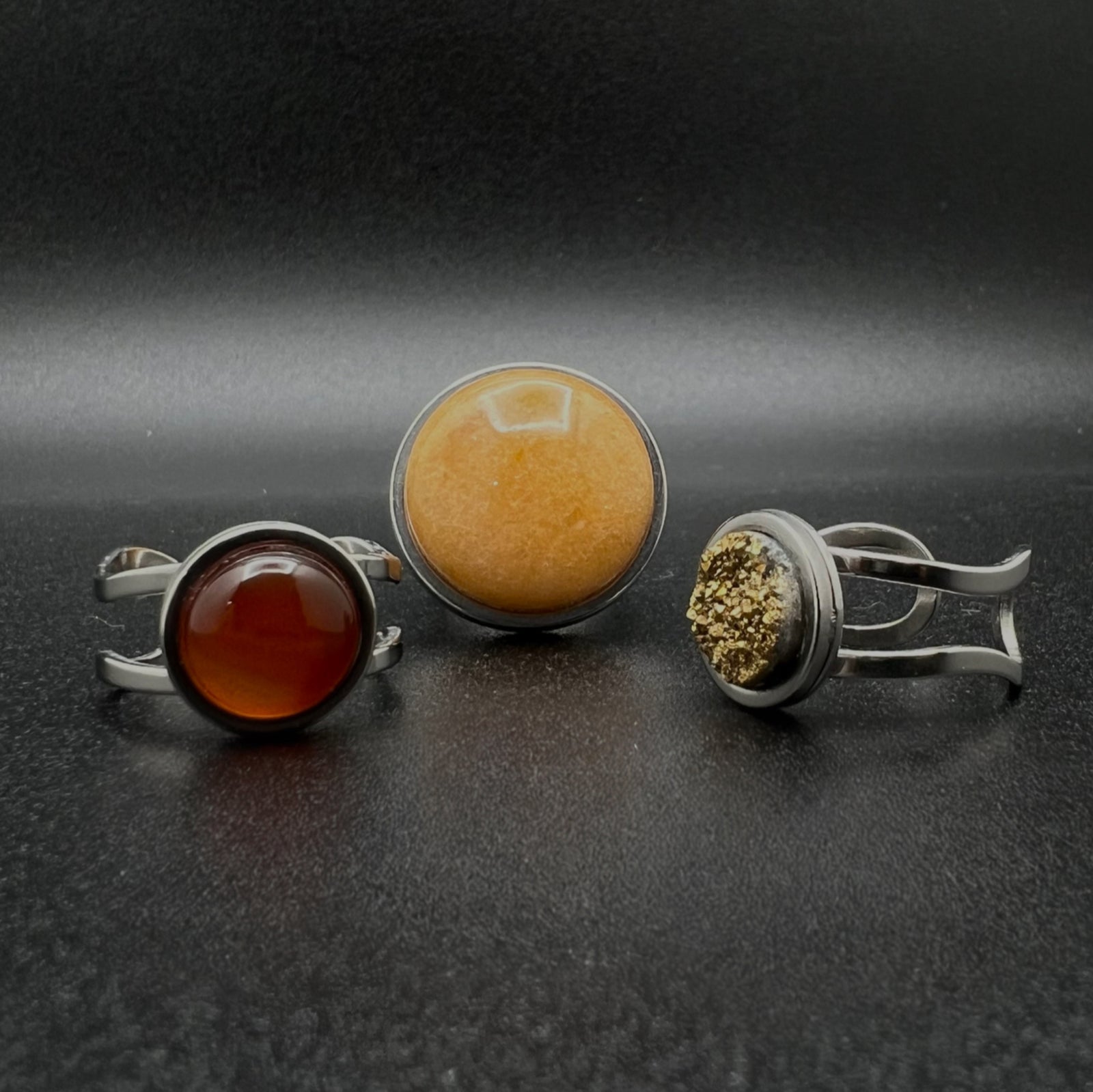 Set of three stainless steel adjustable rings featuring a 20 mm Yellow Aventurine cabochon, 10 mm Gold Druzy cabochon, and 10 mm Carnelian cabochon — Lawless Jewellery.
