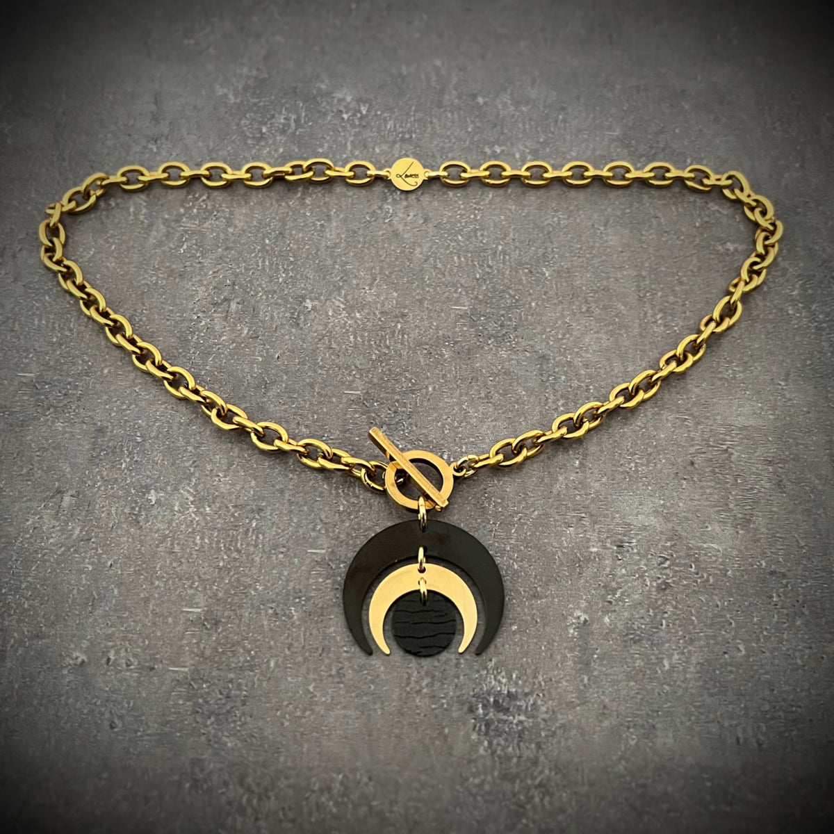 Gold and black stainless steel Luna Phase Necklace with sculptural crescent pendant and chunky curb chain, toggle fastening — Lawless Jewellery