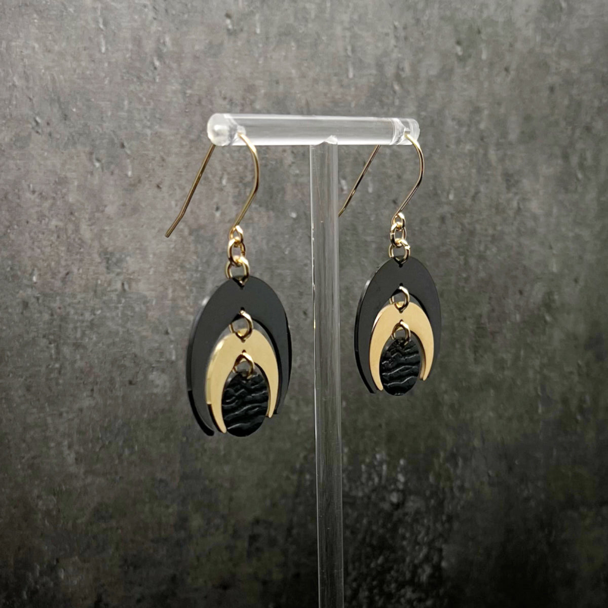 Gold and black stainless steel statement earrings featuring crescent moon and dark disc design, bold and lightweight — Lawless Jewellery.