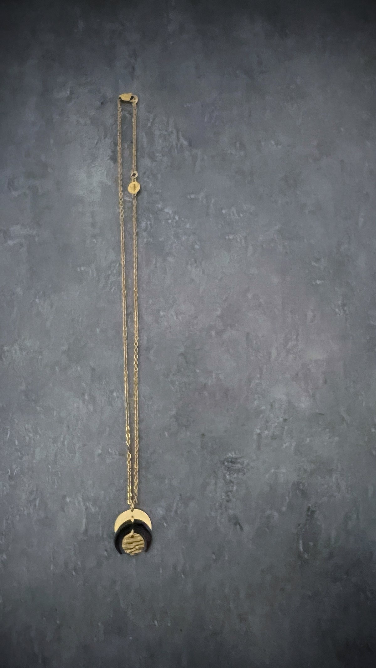 Gold and black stainless steel Luna Phase Mini Necklace with sculptural crescent pendant and adjustable chain — Lawless Jewellery.