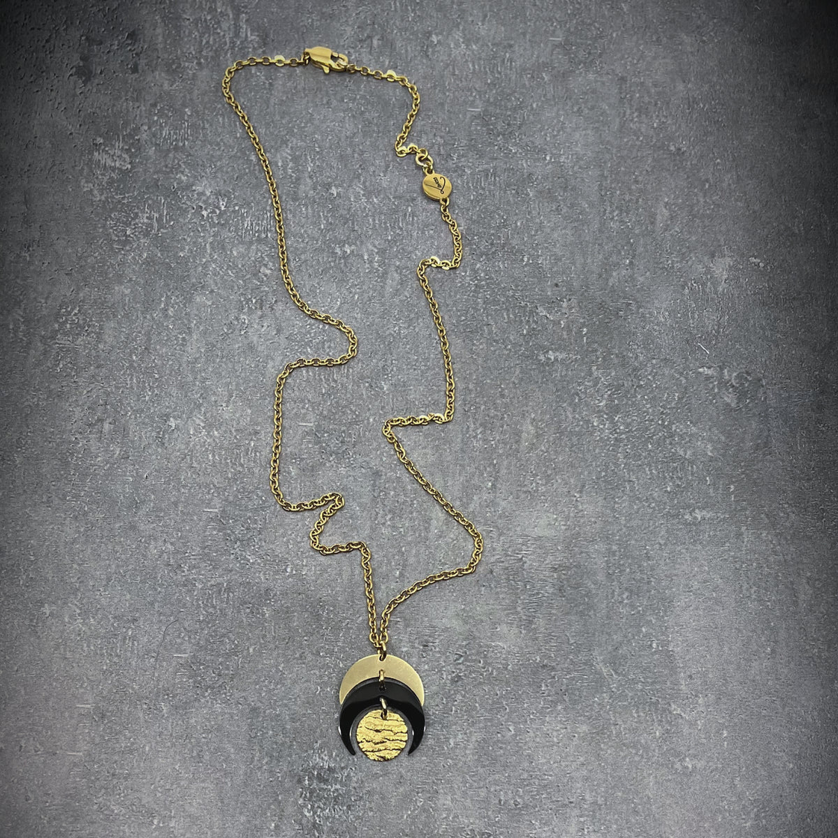 Gold and black stainless steel Luna Phase Mini Necklace with sculptural crescent pendant and adjustable chain — Lawless Jewellery.