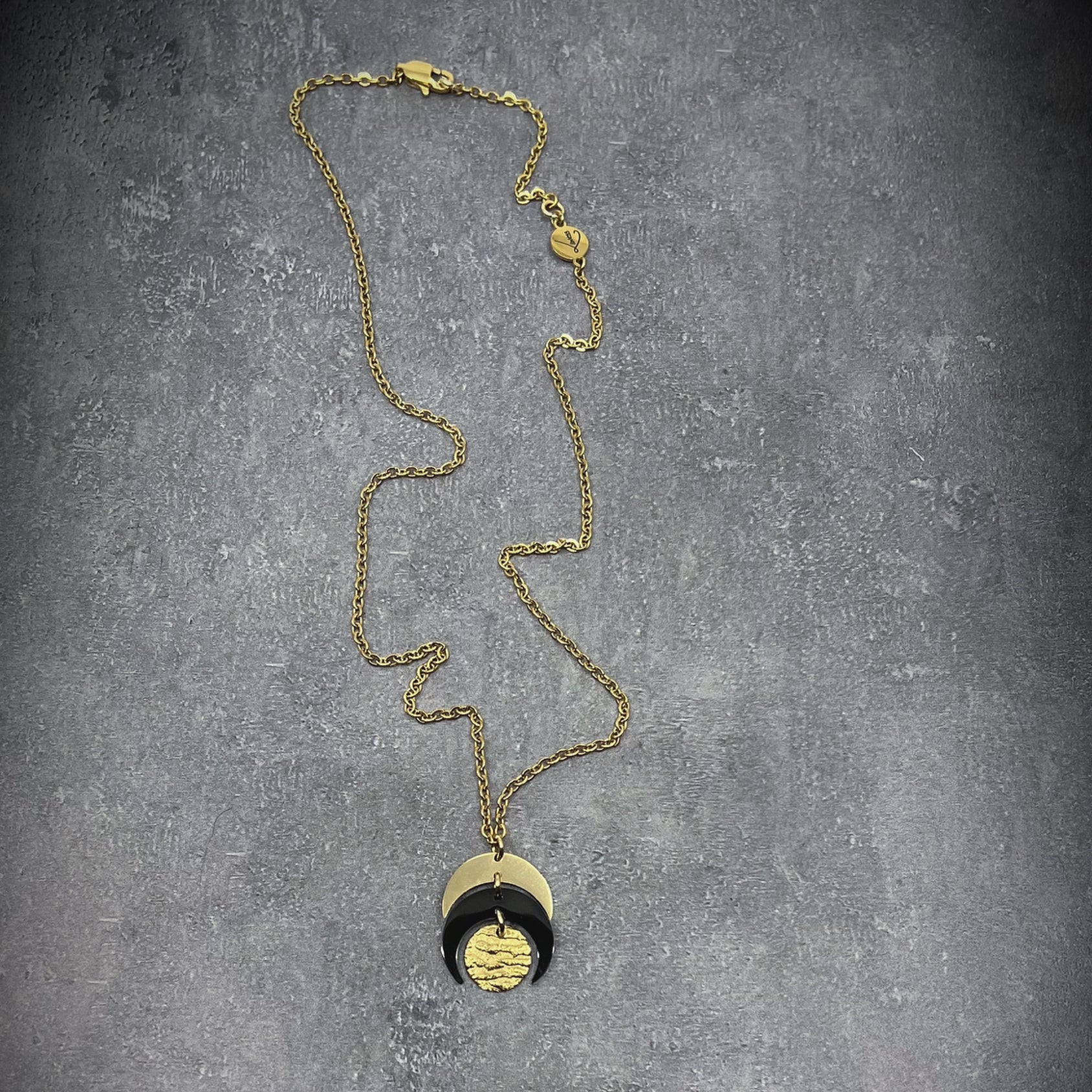 Gold and black stainless steel Luna Phase Mini Necklace with sculptural crescent pendant and adjustable chain — Lawless Jewellery.