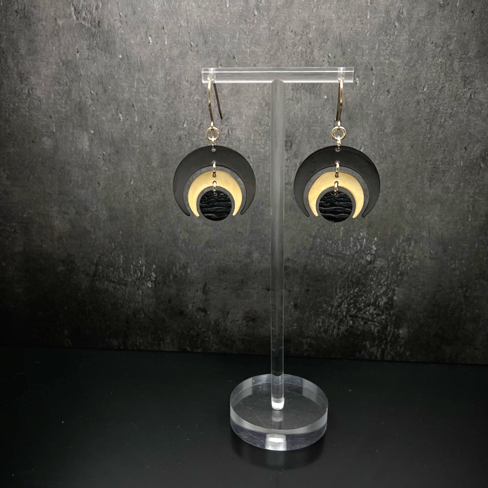 Gold and black stainless steel statement earrings featuring crescent moon and dark disc design, bold and lightweight — Lawless Jewellery.