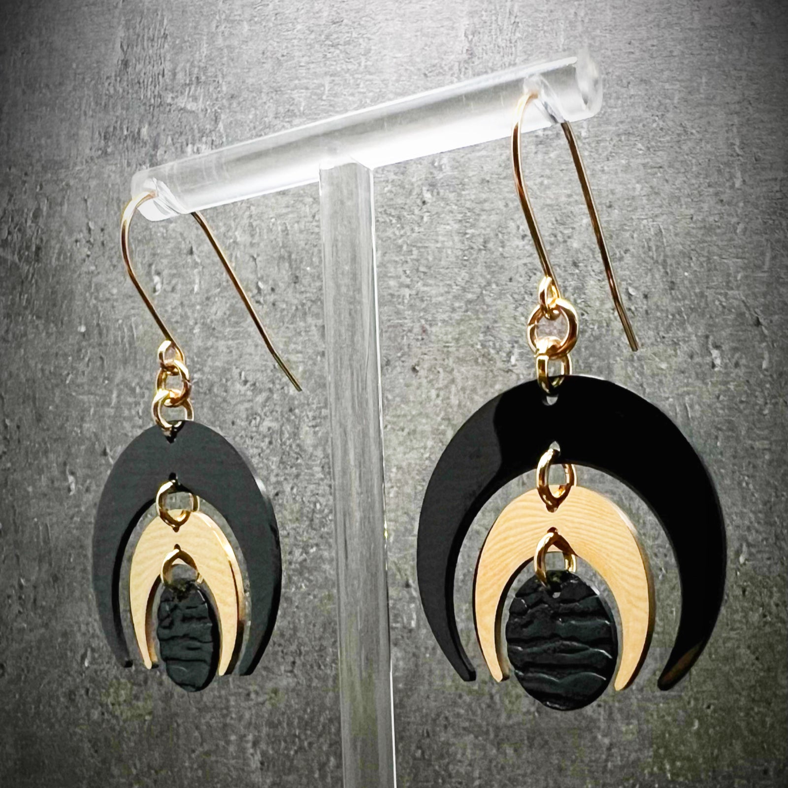 Gold and black stainless steel statement earrings featuring crescent moon and dark disc design, bold and lightweight — Lawless Jewellery.