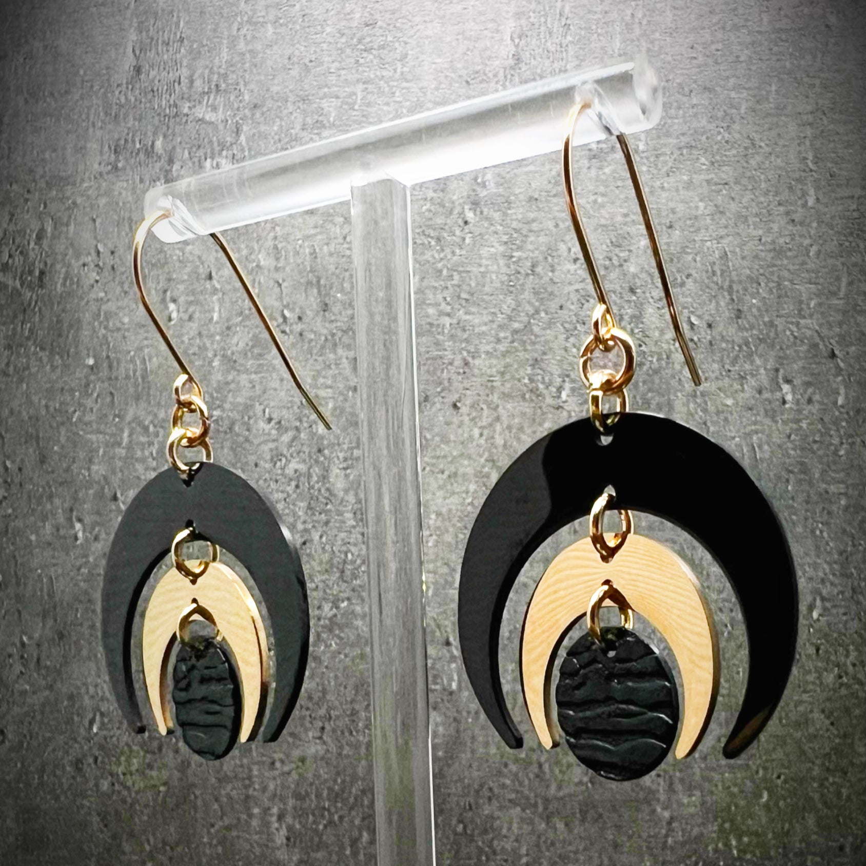 Gold and black stainless steel statement earrings featuring crescent moon and dark disc design, bold and lightweight — Lawless Jewellery.