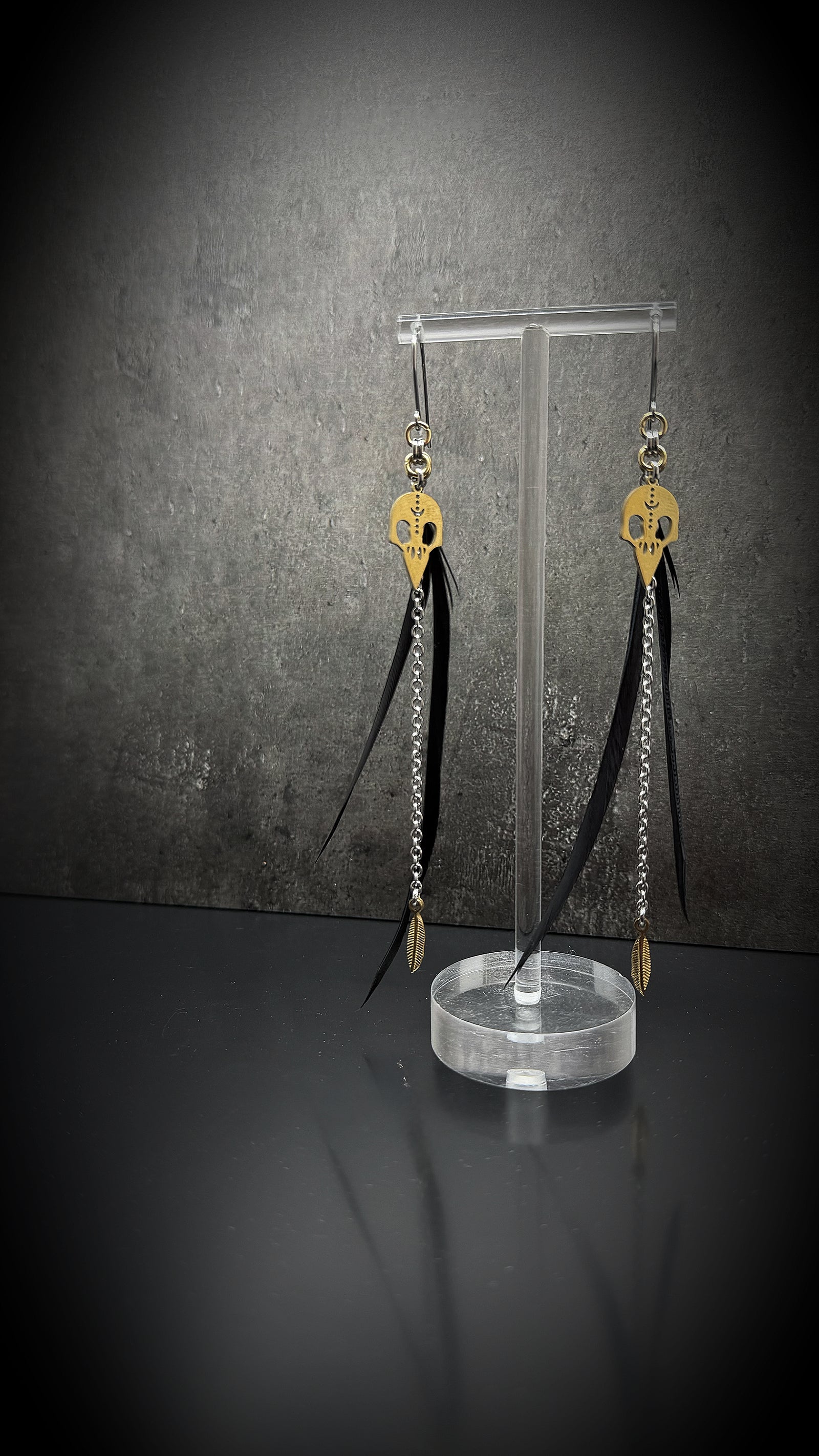 Black, silver, and gold stainless steel earrings with real feather detailing and chain accents — lightweight statement design — Lawless Jewellery.