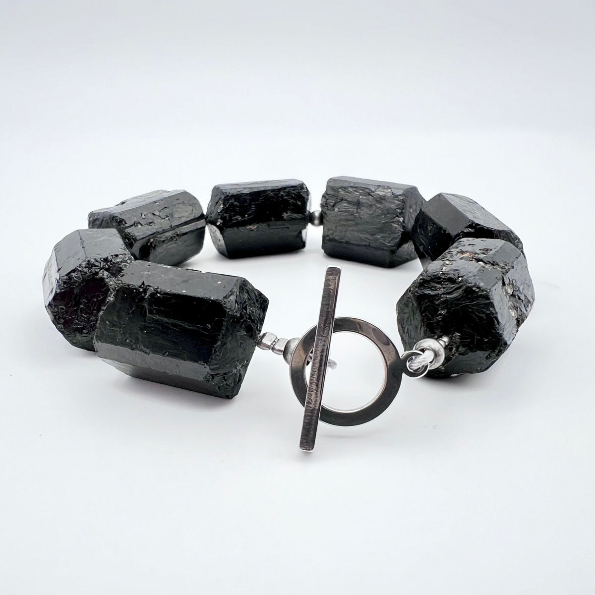 Chunky cuff bracelet featuring barrel-cut Black Tourmaline gemstones set in stainless steel with toggle clasp — bold, protective, and grounding — Lawless Jewellery.