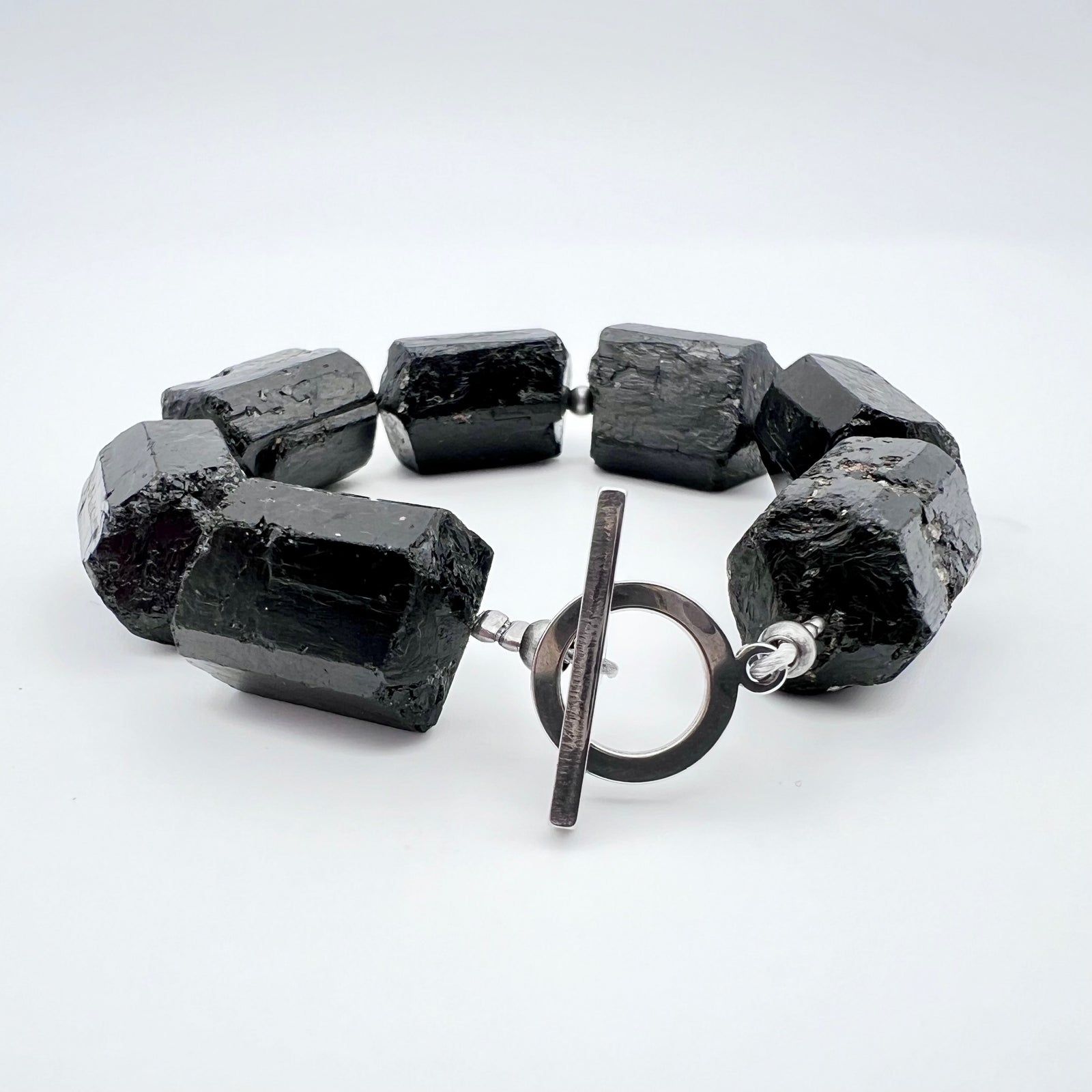 Chunky cuff bracelet featuring barrel-cut Black Tourmaline gemstones set in stainless steel with toggle clasp — bold, protective, and grounding — Lawless Jewellery.