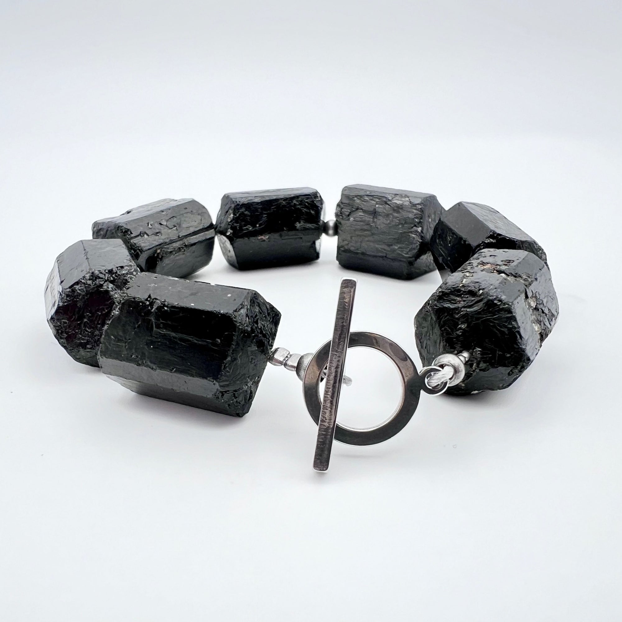 Chunky cuff bracelet featuring barrel-cut Black Tourmaline gemstones set in stainless steel with toggle clasp — bold, protective, and grounding — Lawless Jewellery.