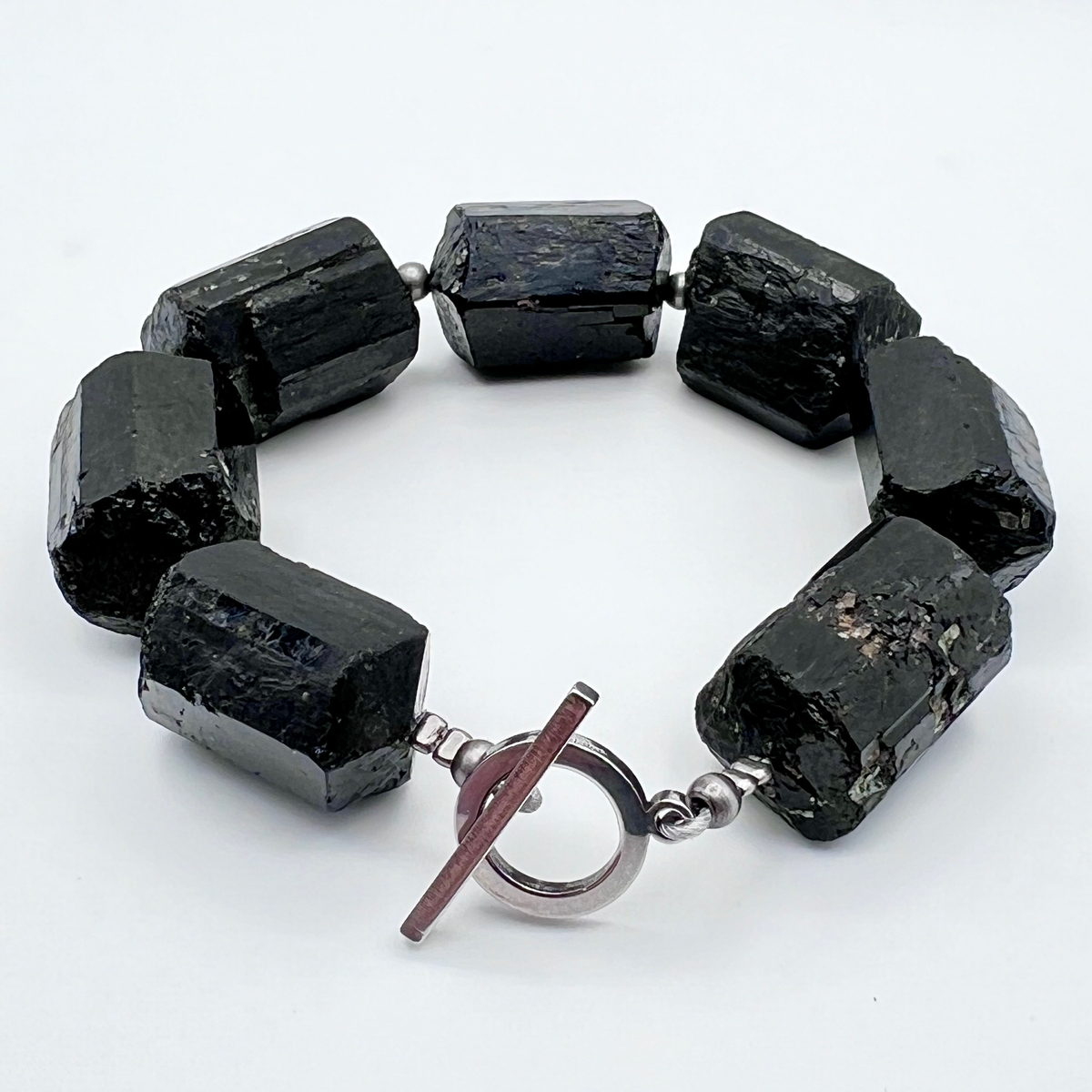 Chunky cuff bracelet featuring barrel-cut Black Tourmaline gemstones set in stainless steel with toggle clasp — bold, protective, and grounding — Lawless Jewellery.