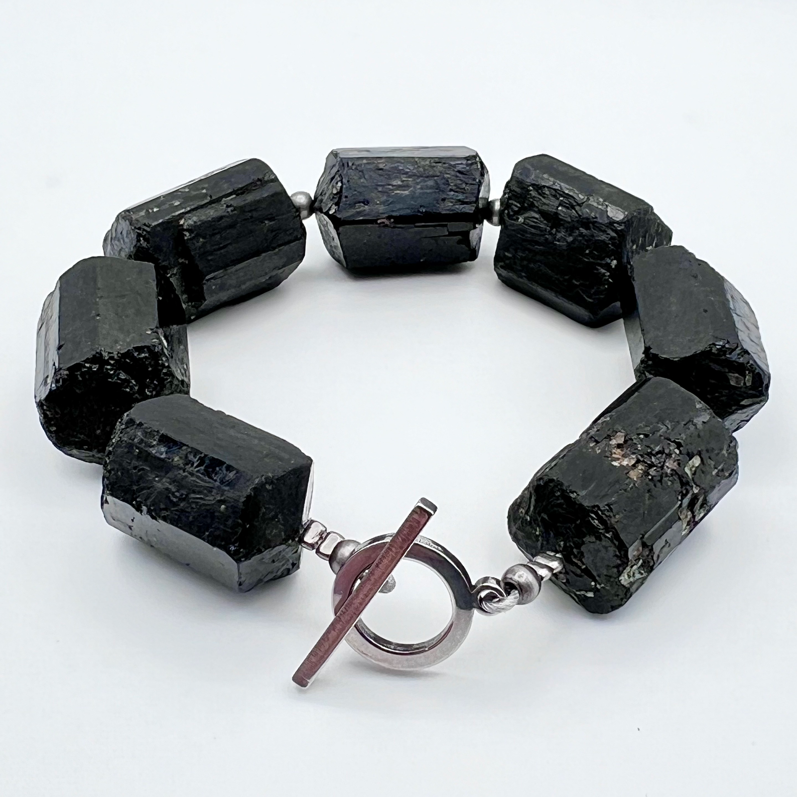 Chunky cuff bracelet featuring barrel-cut Black Tourmaline gemstones set in stainless steel with toggle clasp — bold, protective, and grounding — Lawless Jewellery.