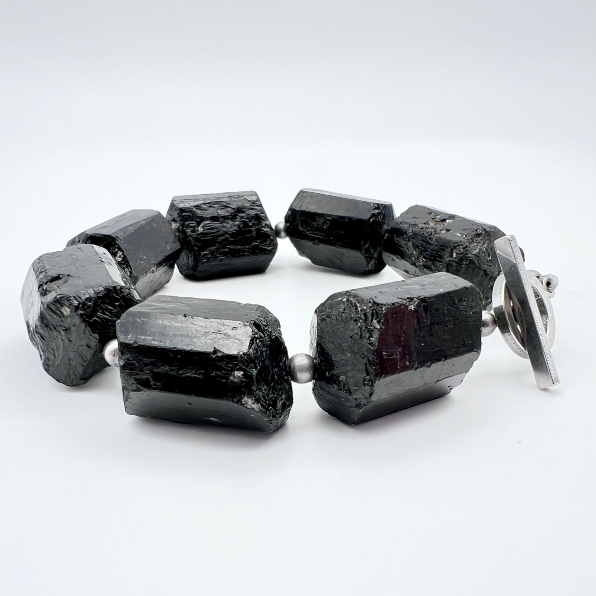 Chunky cuff bracelet featuring barrel-cut Black Tourmaline gemstones set in stainless steel with toggle clasp — bold, protective, and grounding — Lawless Jewellery.