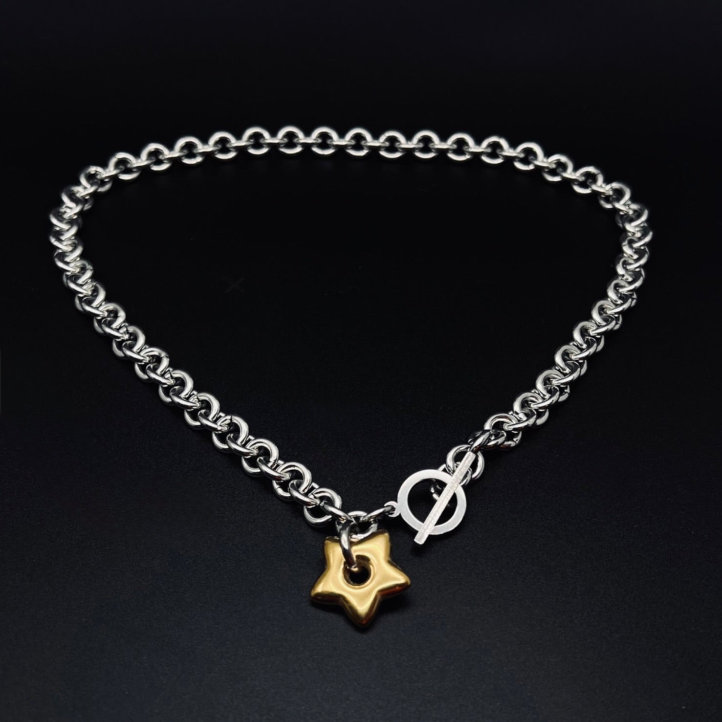 woman wearing a Silver stainless steel chain necklace with gold star pendant and toggle clasp, Urania Axis Necklace by Lawless Jewellery 